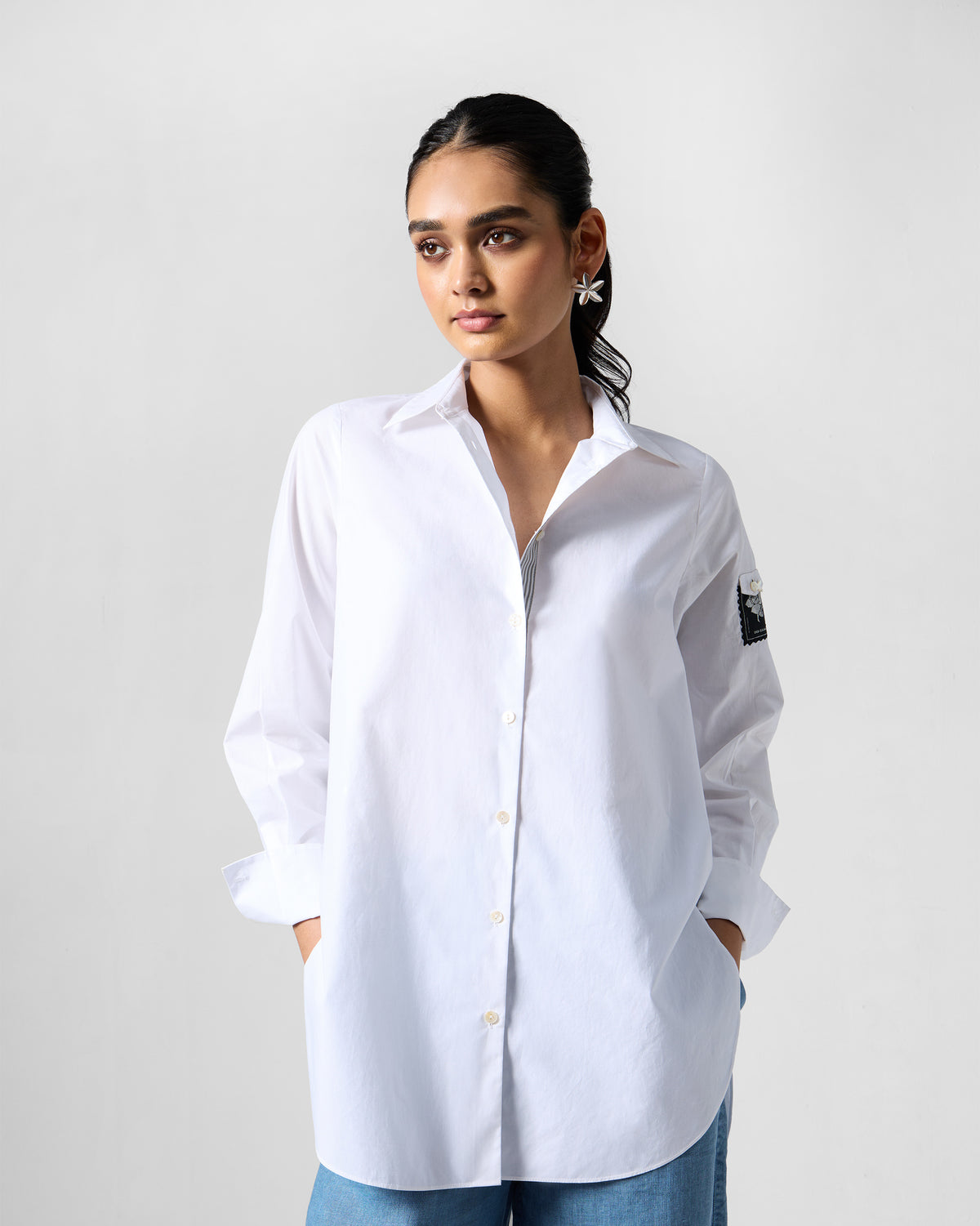 Person wearing a white Trench shirt with a sleeve patch.