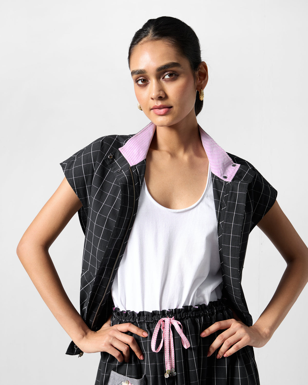 Person wearing an open black-and-white checked Renai top with a striped reverse collar.