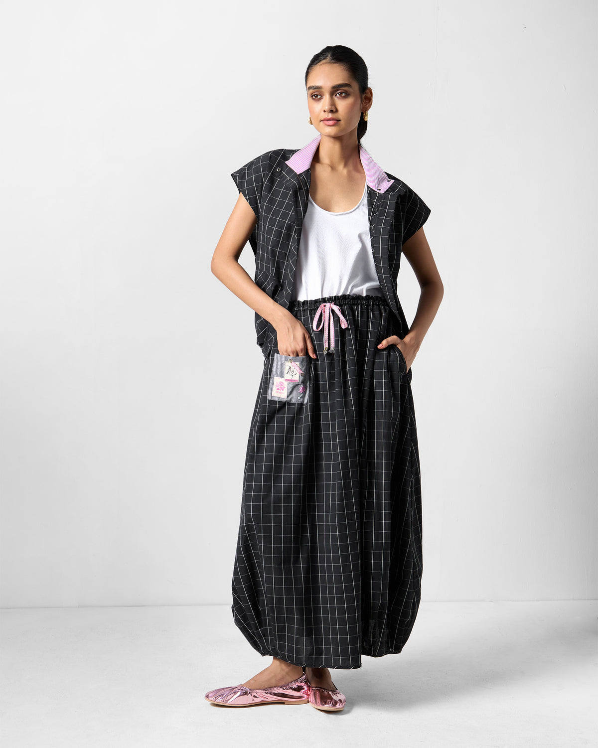 Person wearing a black-and-white checked Renai top with a lavender collar.