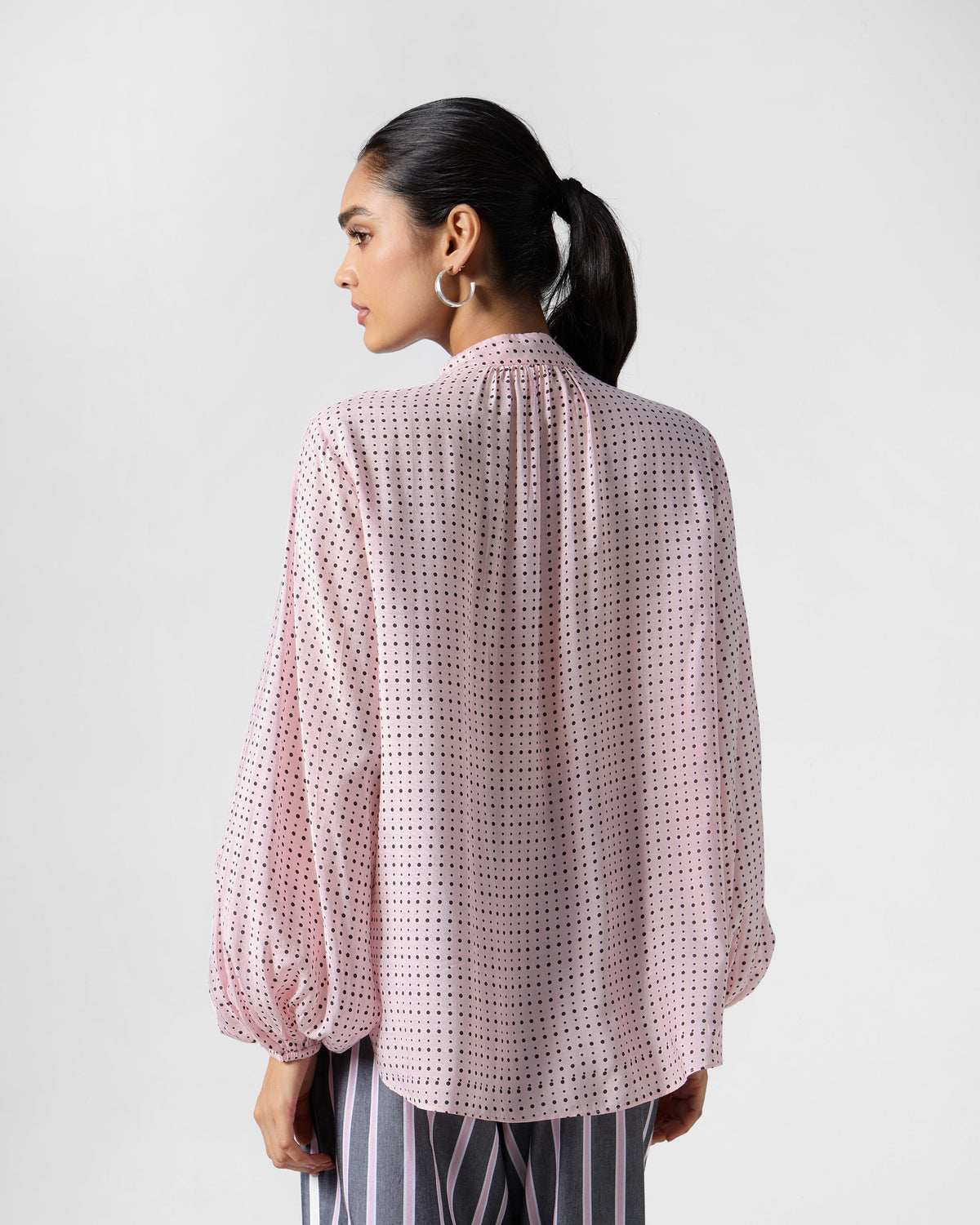 Back of a pink polka-dot Spring tie shirt with a gathered neckline.