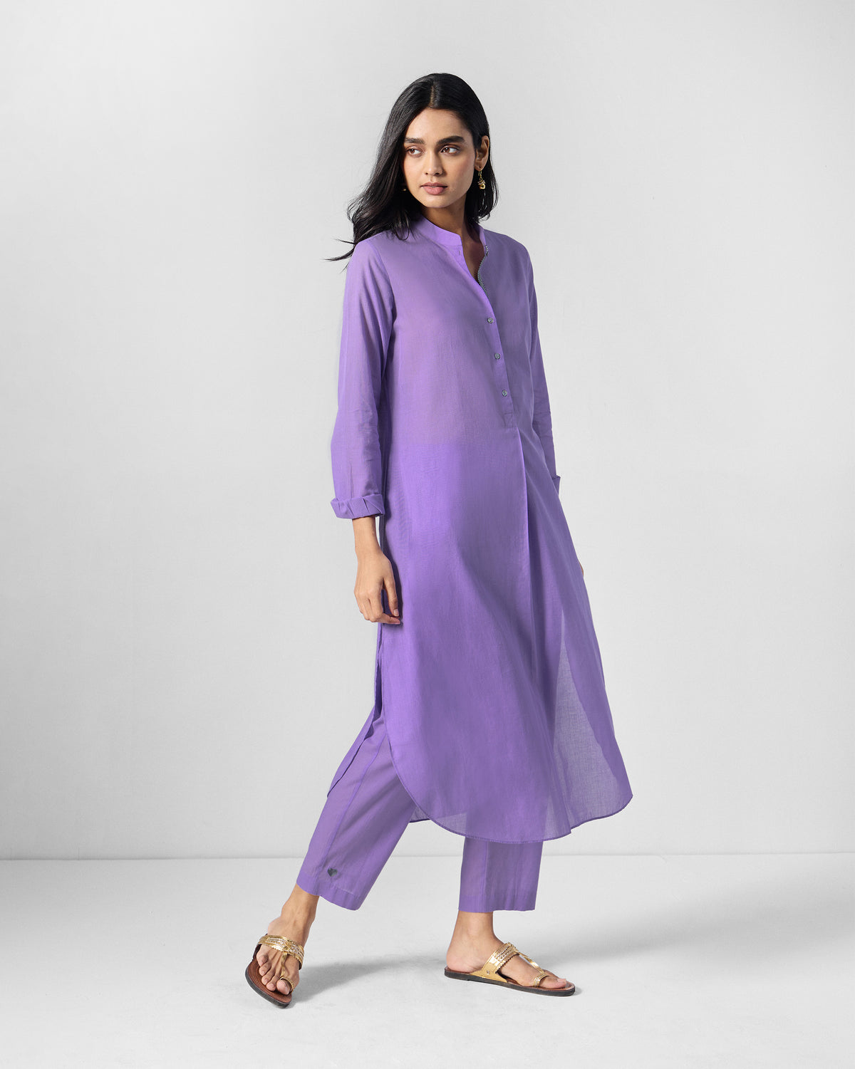 Person wearing a lilac long kurta with a curved hem and button placket.