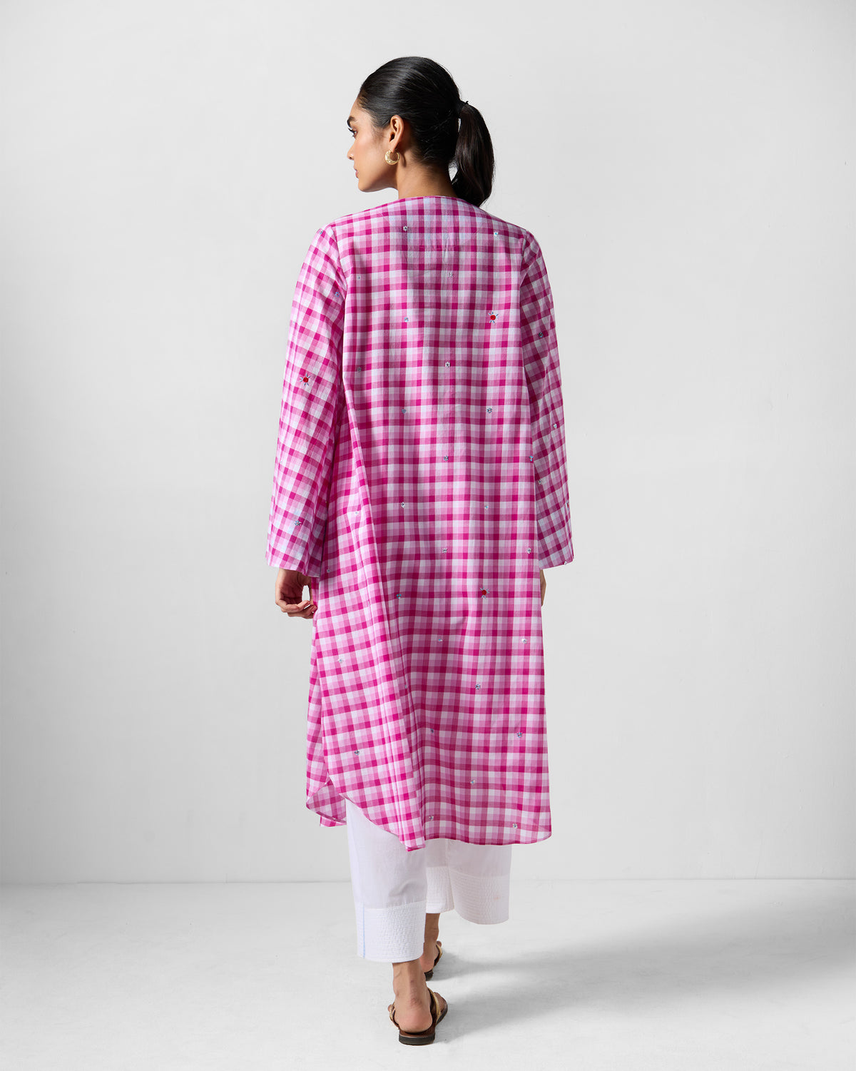 Back of a pink and white check embroidered Amaya tunic worn by a person.