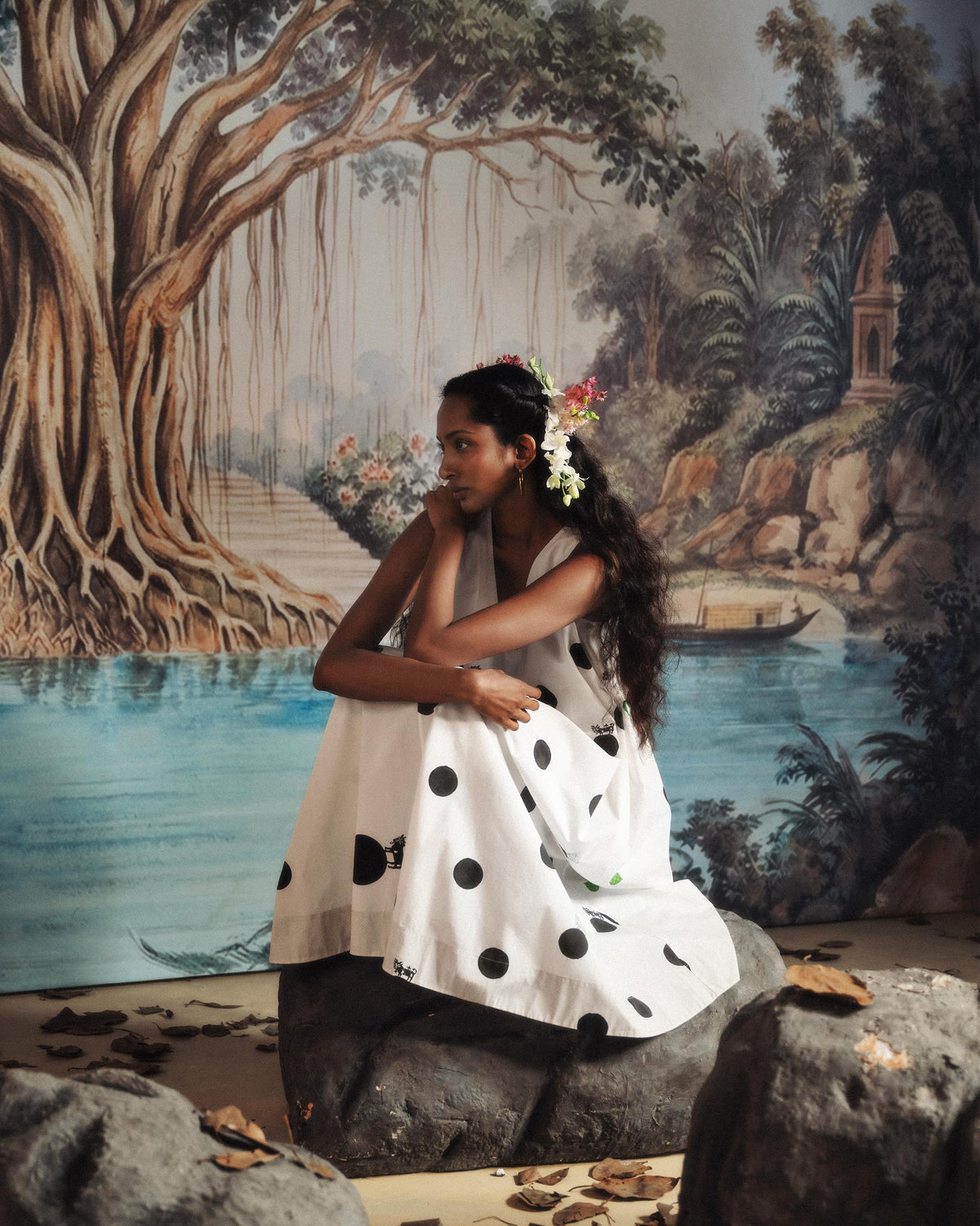Person wearing a white polka-dot dress while seated.