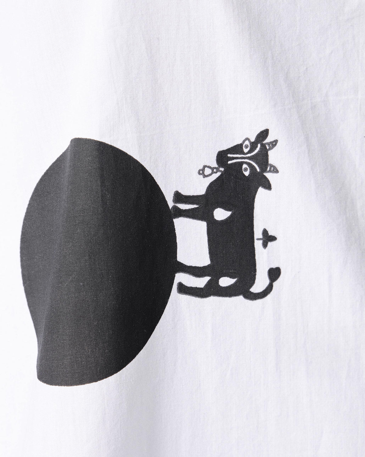 Close-up of a white dress with a black cow print motif.
