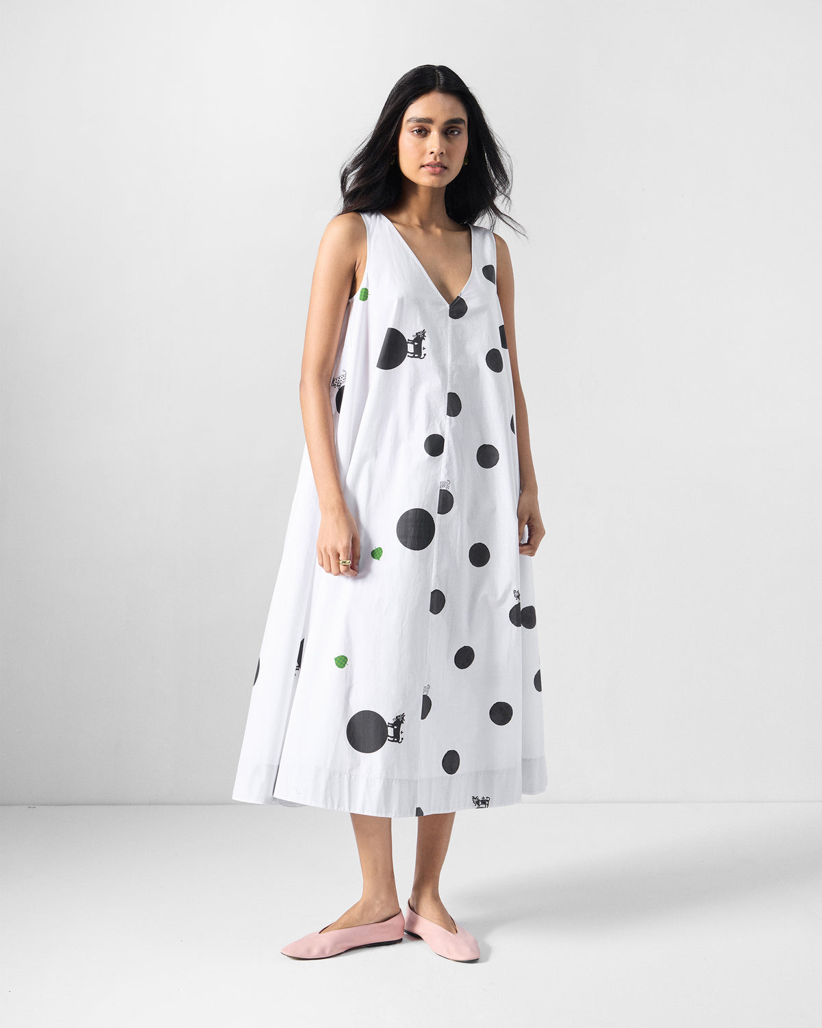 Person wearing a white A-line dress with black polka dots.