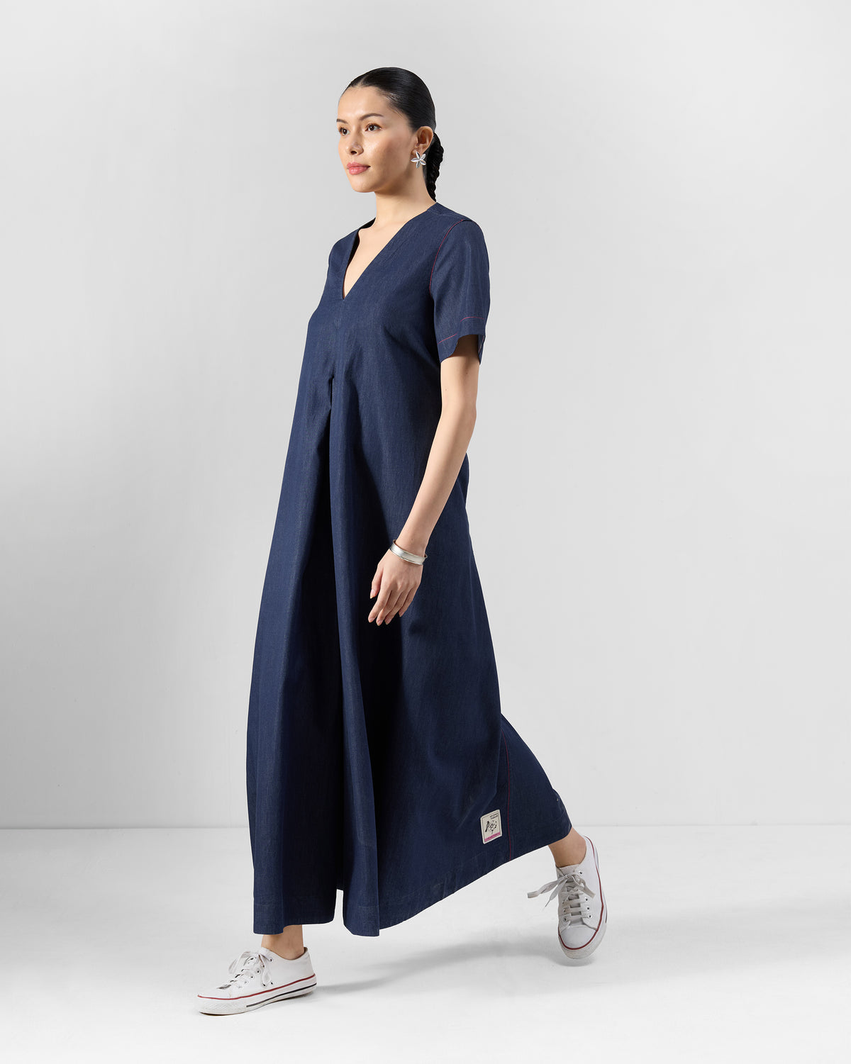 Side view of a navy Peru jumpsuit showing its wide-leg silhouette.