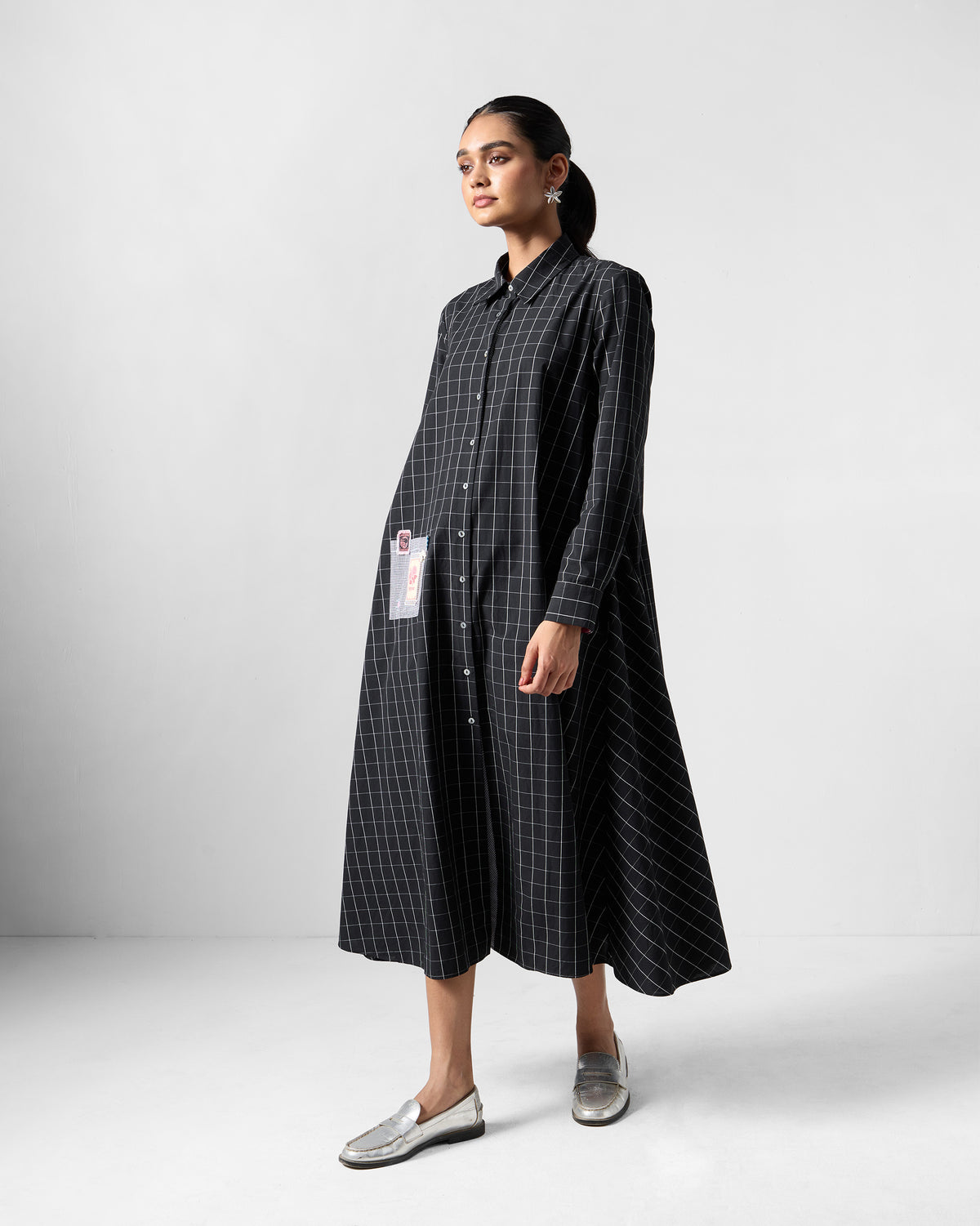 Three-quarter view of a black check Spiti shirt dress.