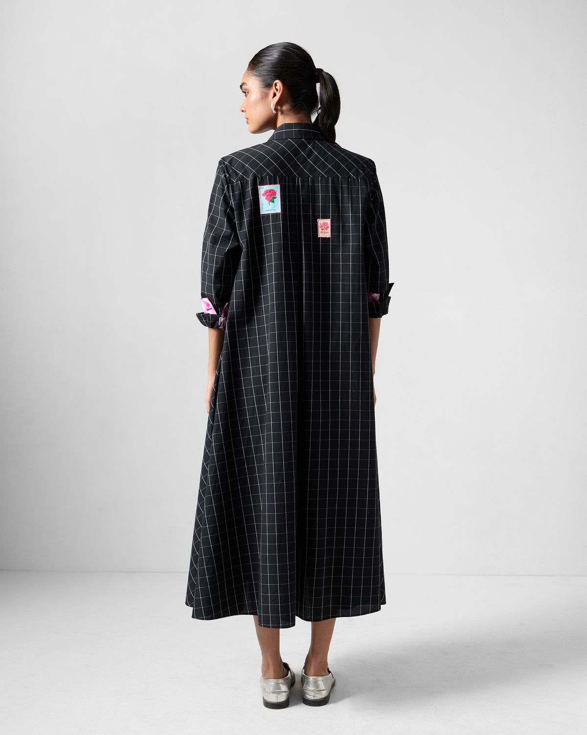 Back of a black check Spiti shirt dress with rose patches.