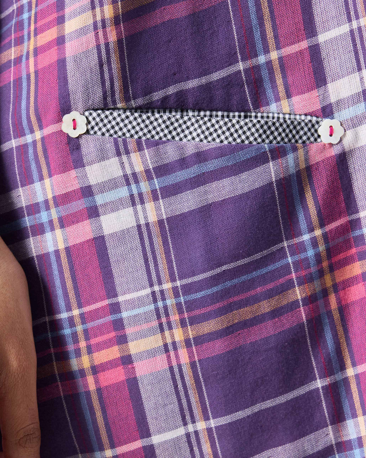 Close-up of a Daye dress welt pocket with flower buttons.