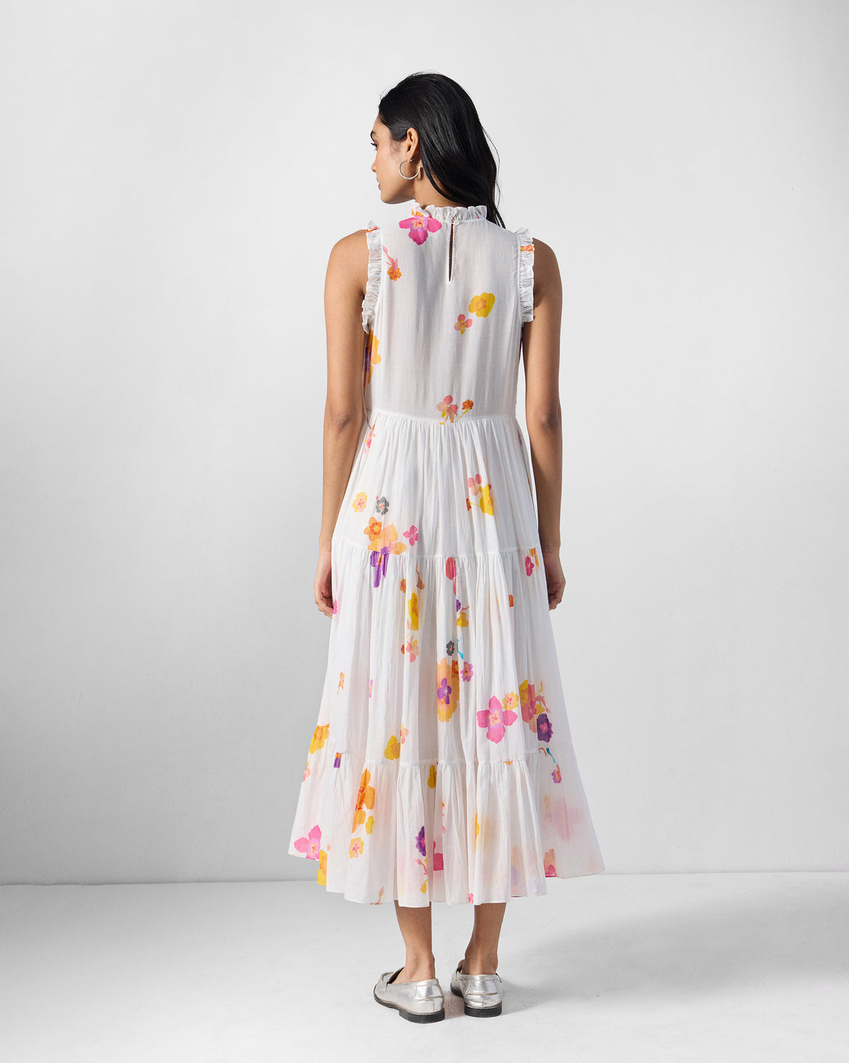 Back of an ivory Reah dress with a keyhole neck and tiered skirt.