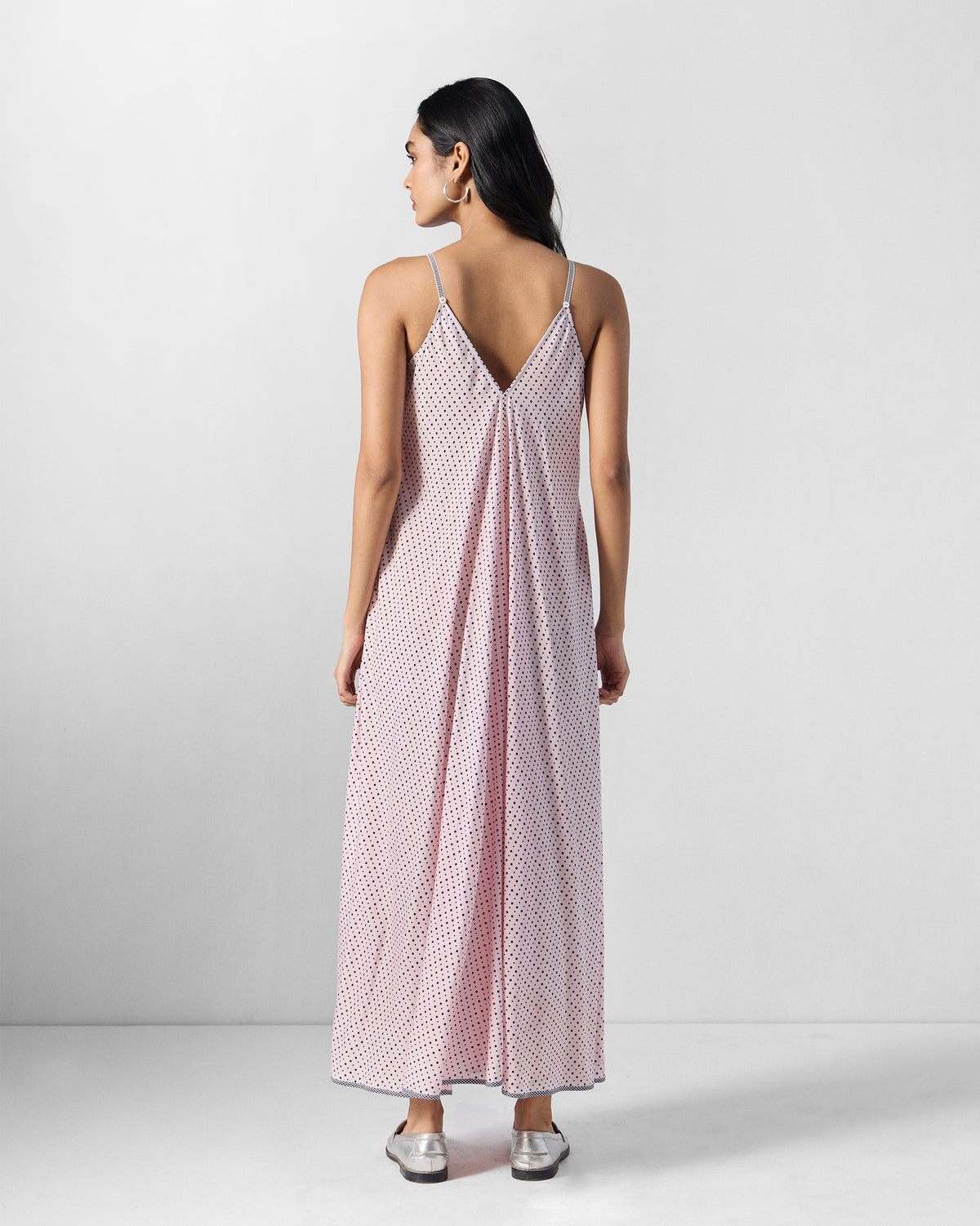 Back of a pink and charcoal printed V-neck strappy dress with thin straps.