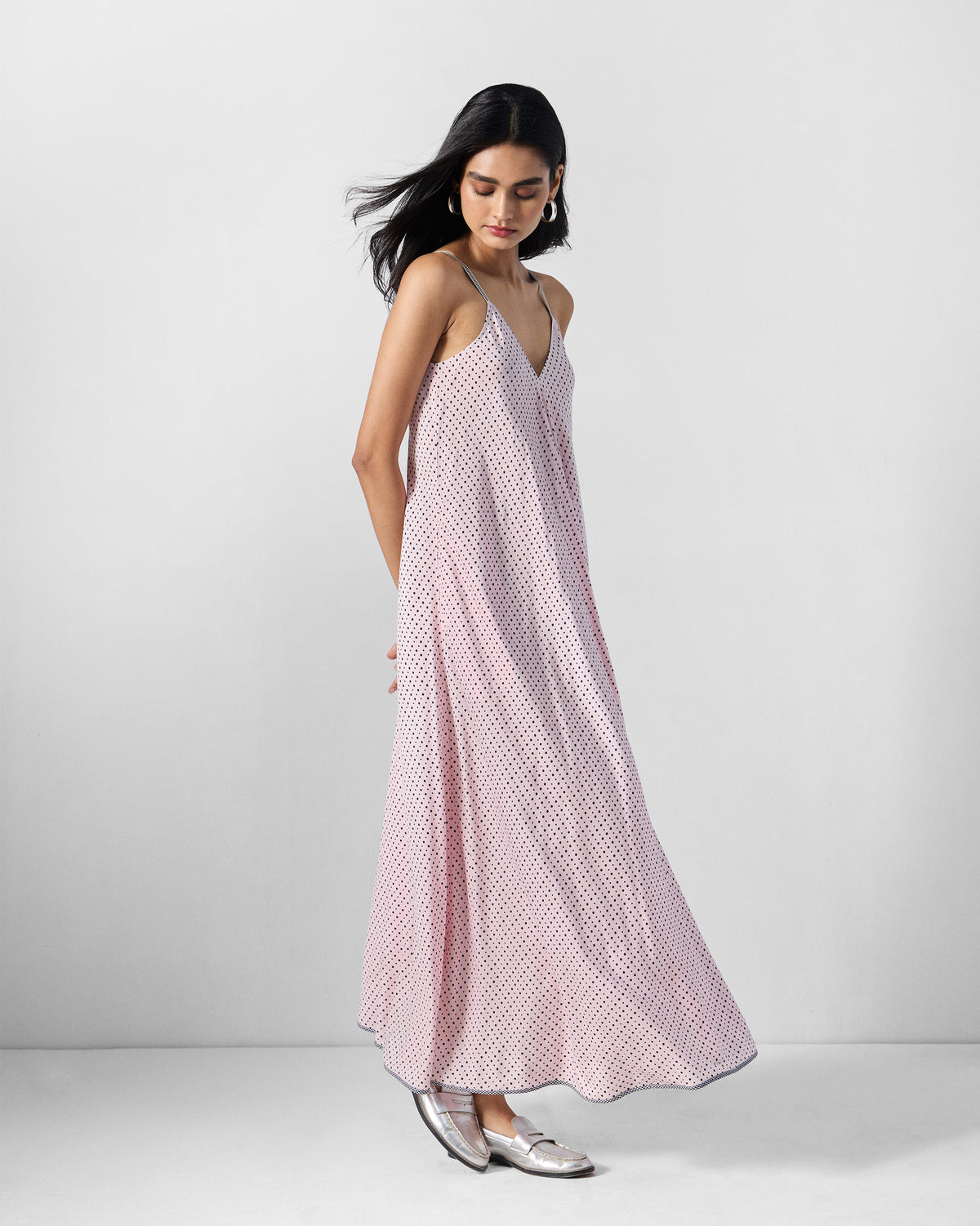 Person wearing a pink and charcoal printed V-neck strappy maxi dress showing the A-line drape.