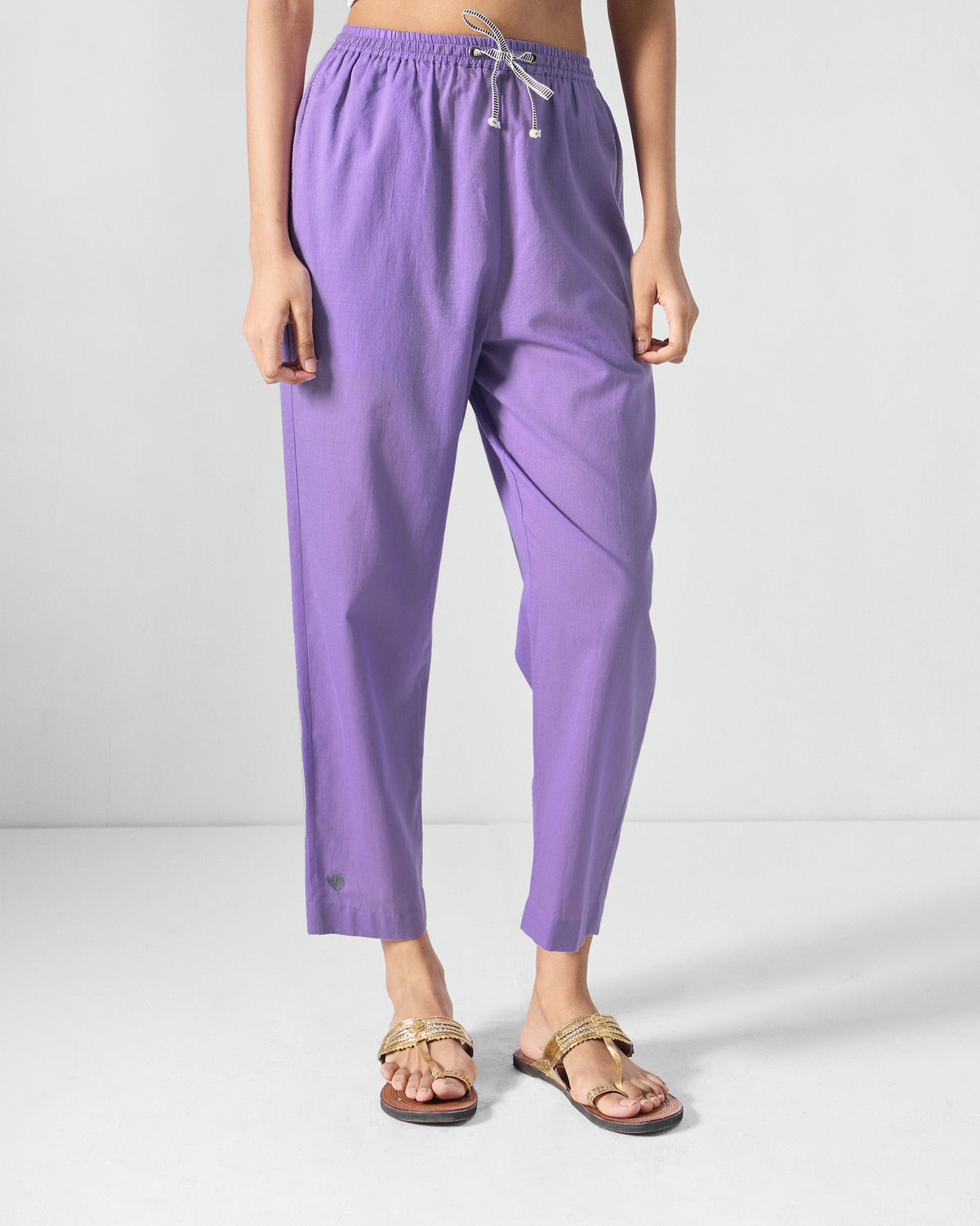 Person wearing lilac Kinatra Pants with a drawstring waist and cropped straight legs.