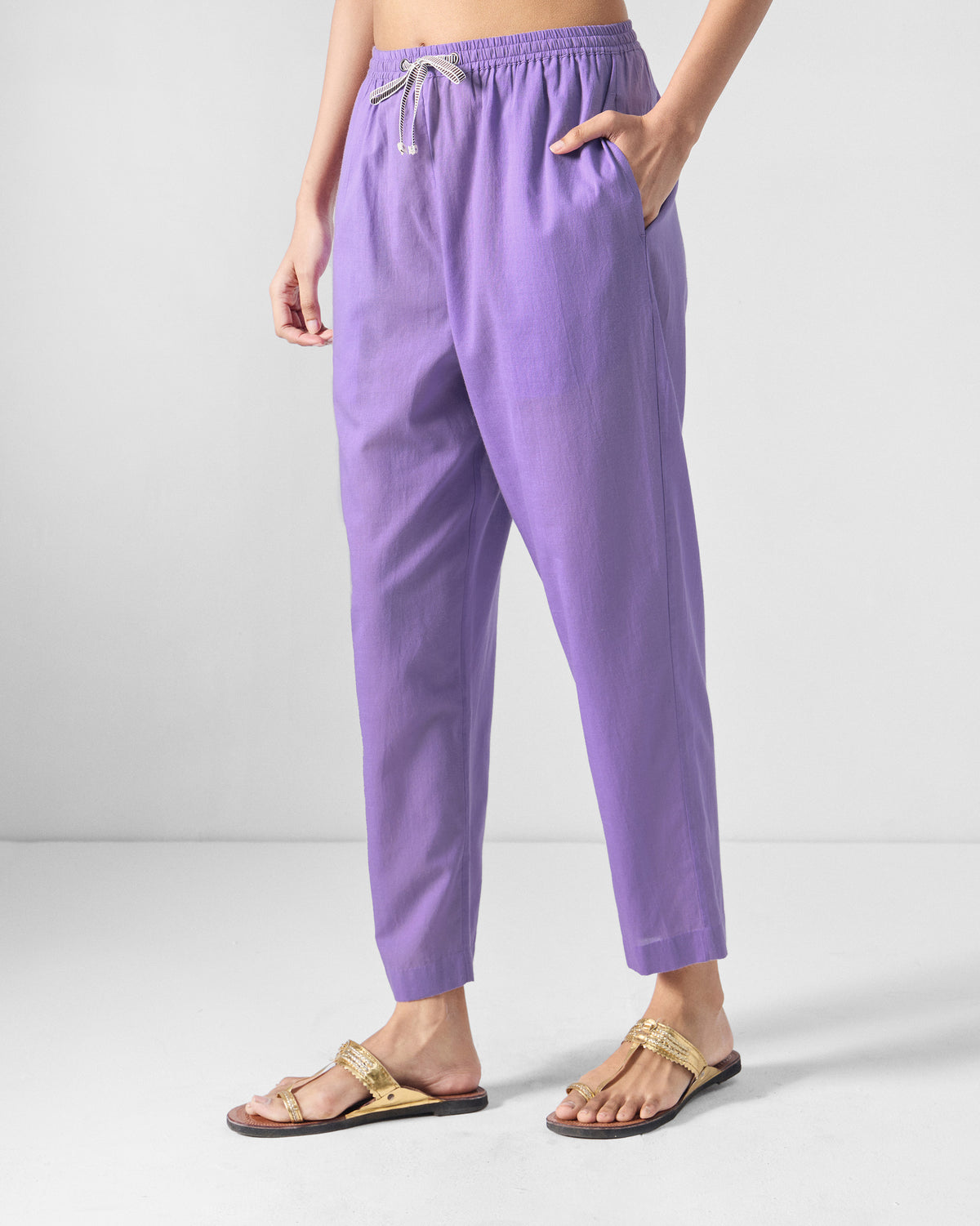 Person wearing lilac Kinatra Pants with a hand in the side pocket.