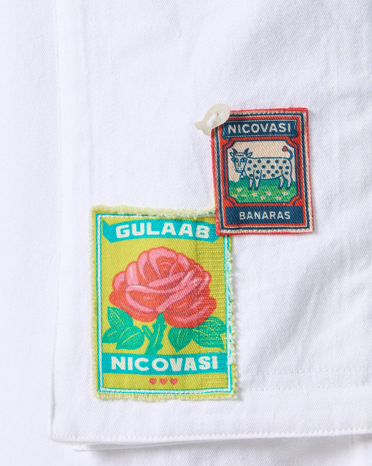 Close-up of Banaras cow and gulab patches on white Ella culottes.