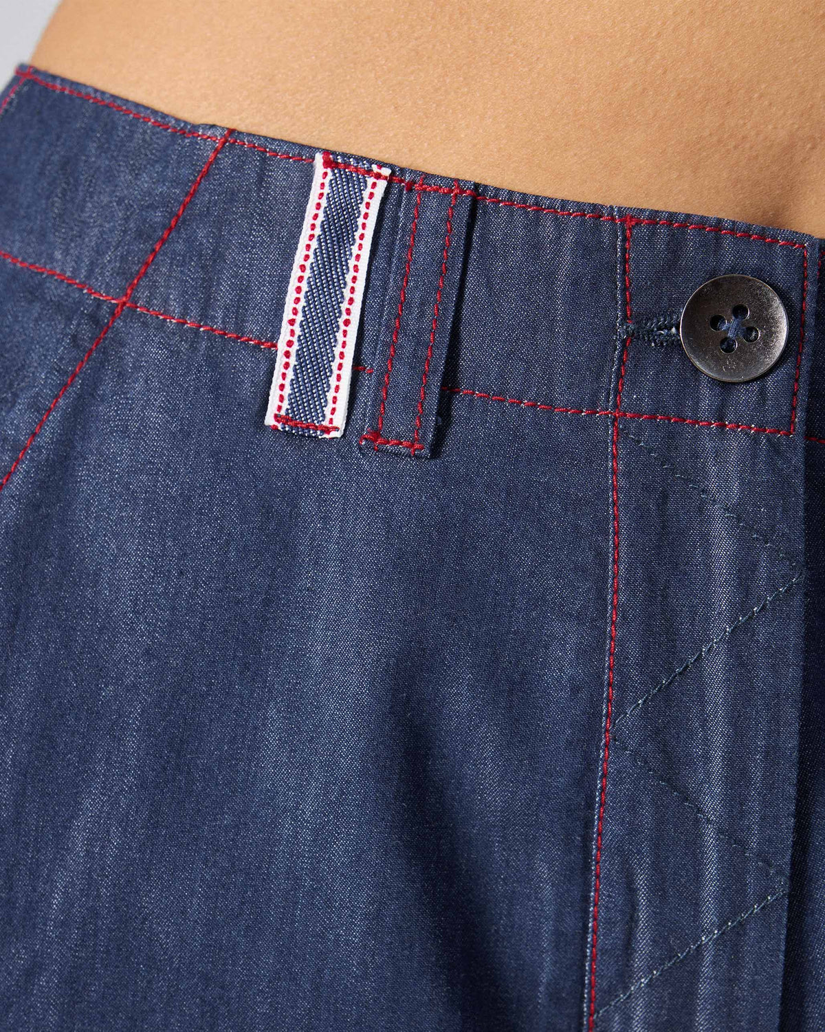 Close-up of blue Ella culottes showing a striped belt loop and red topstitching.