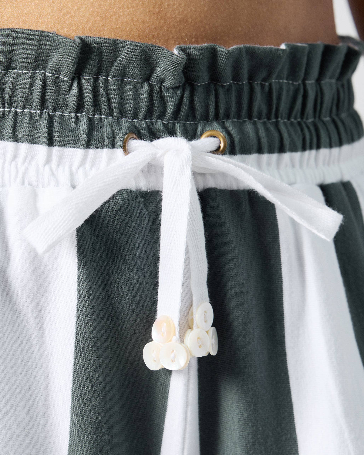 Close-up of the drawstring and paperbag waist on charcoal and white striped Nova pants.