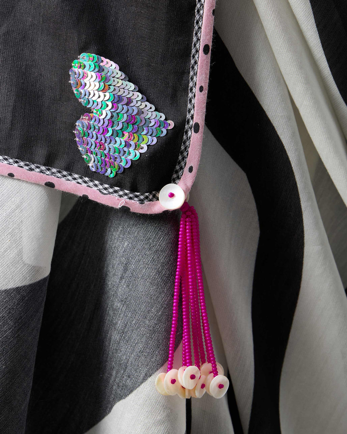 Close-up of a sequin heart and pink beaded tassel on an Ella sari.