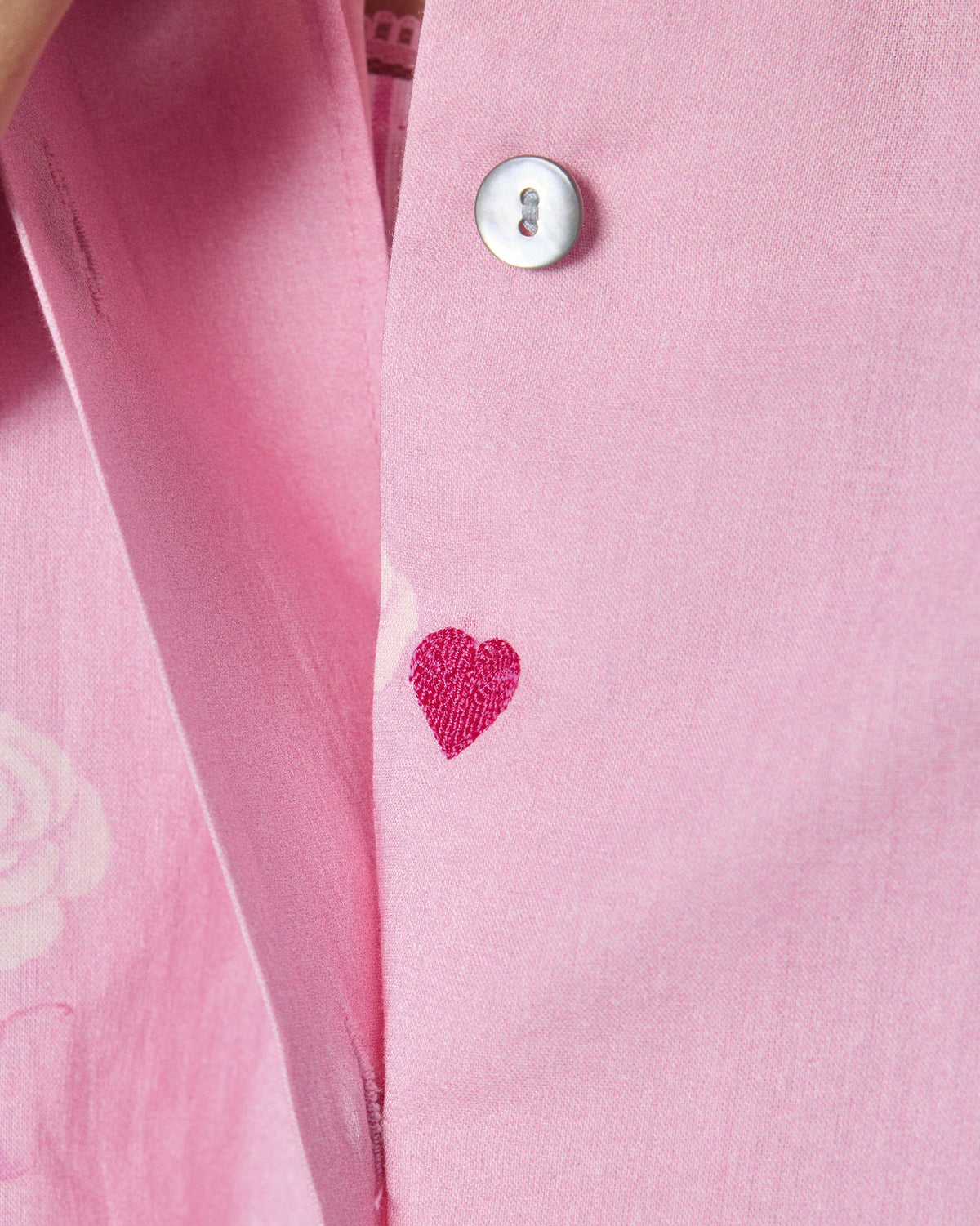 Close-up of a magenta heart on a soft pink Raha tunic.