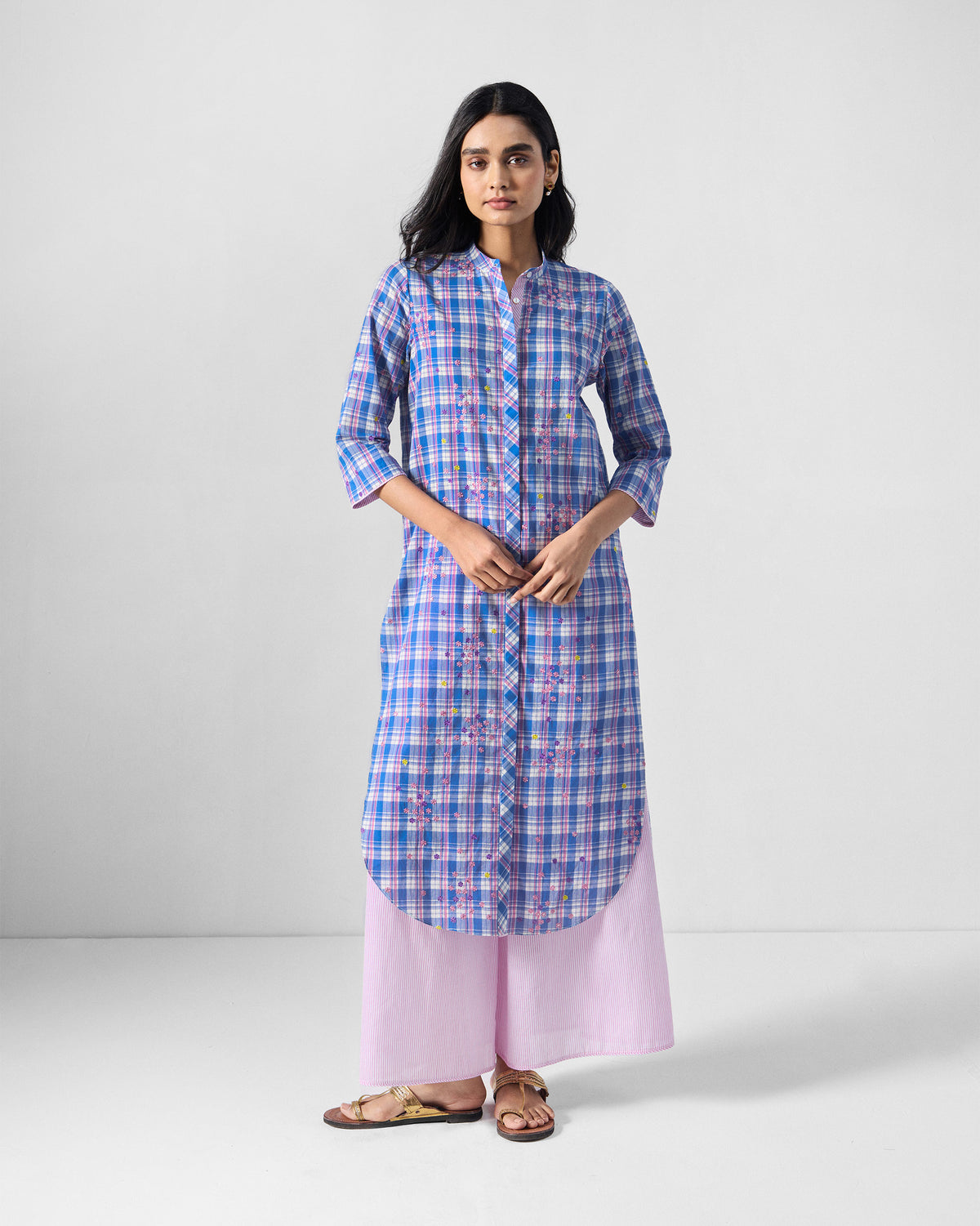 Person wearing a blue and pink check Eka Kurta with a curved hem.