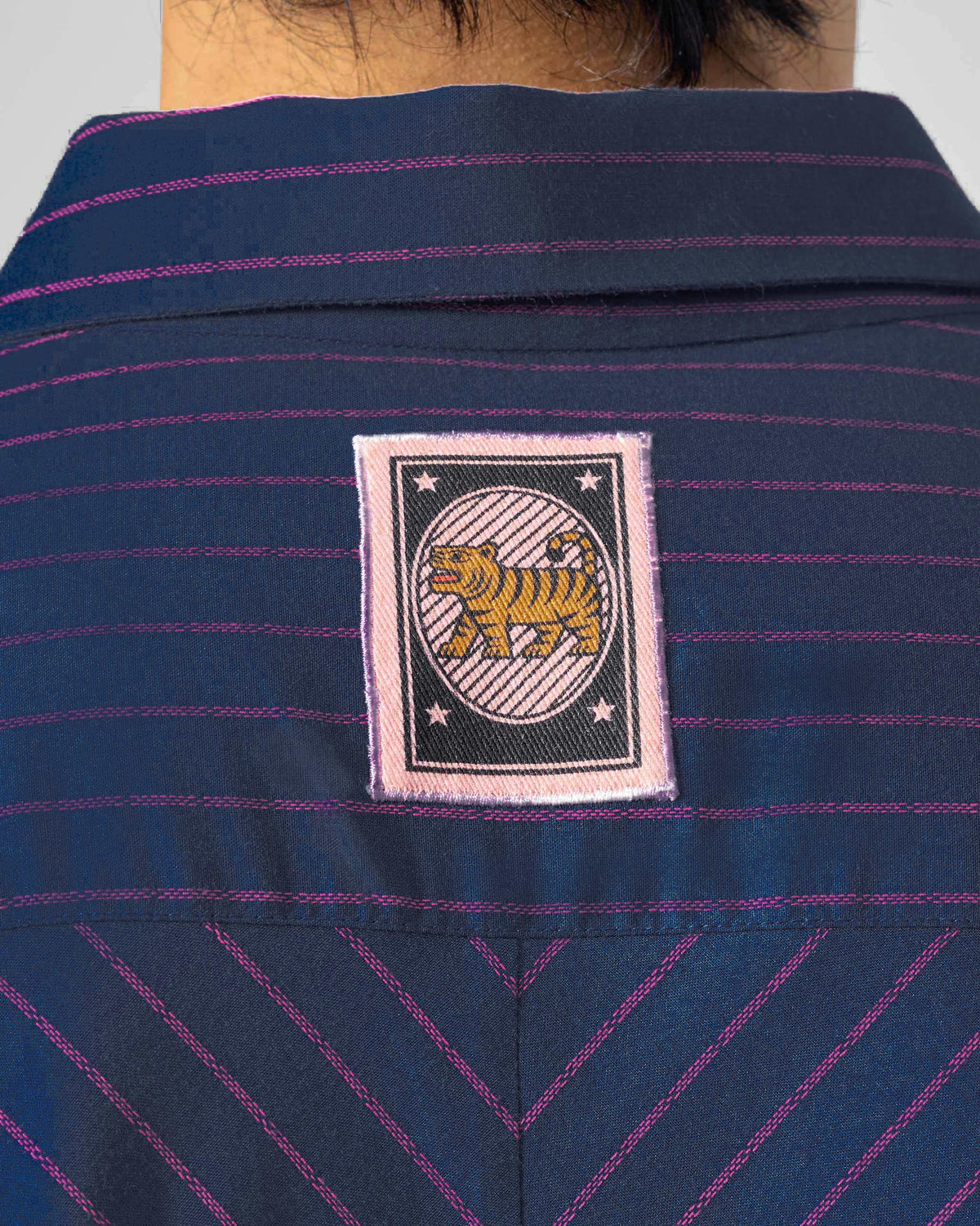 Close-up of a tiger stamp on the Flow shirt back yoke.