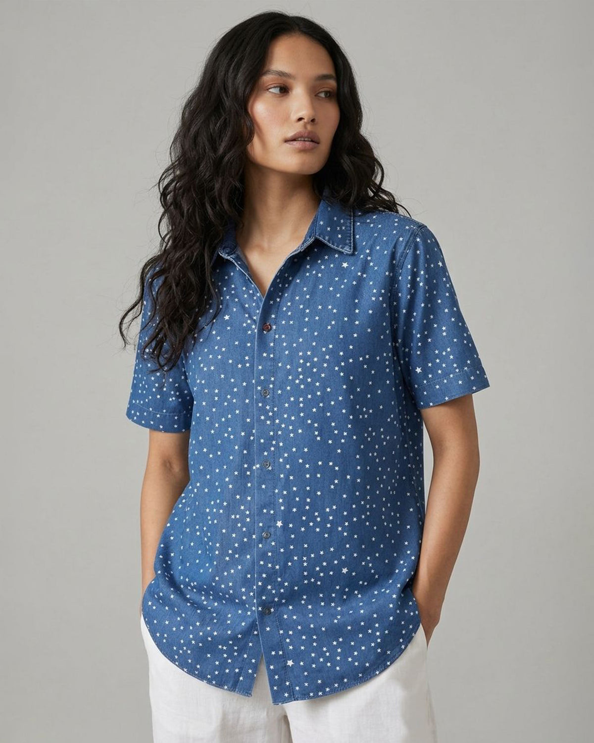 Person wearing a denim Spark shirt with a white star print.