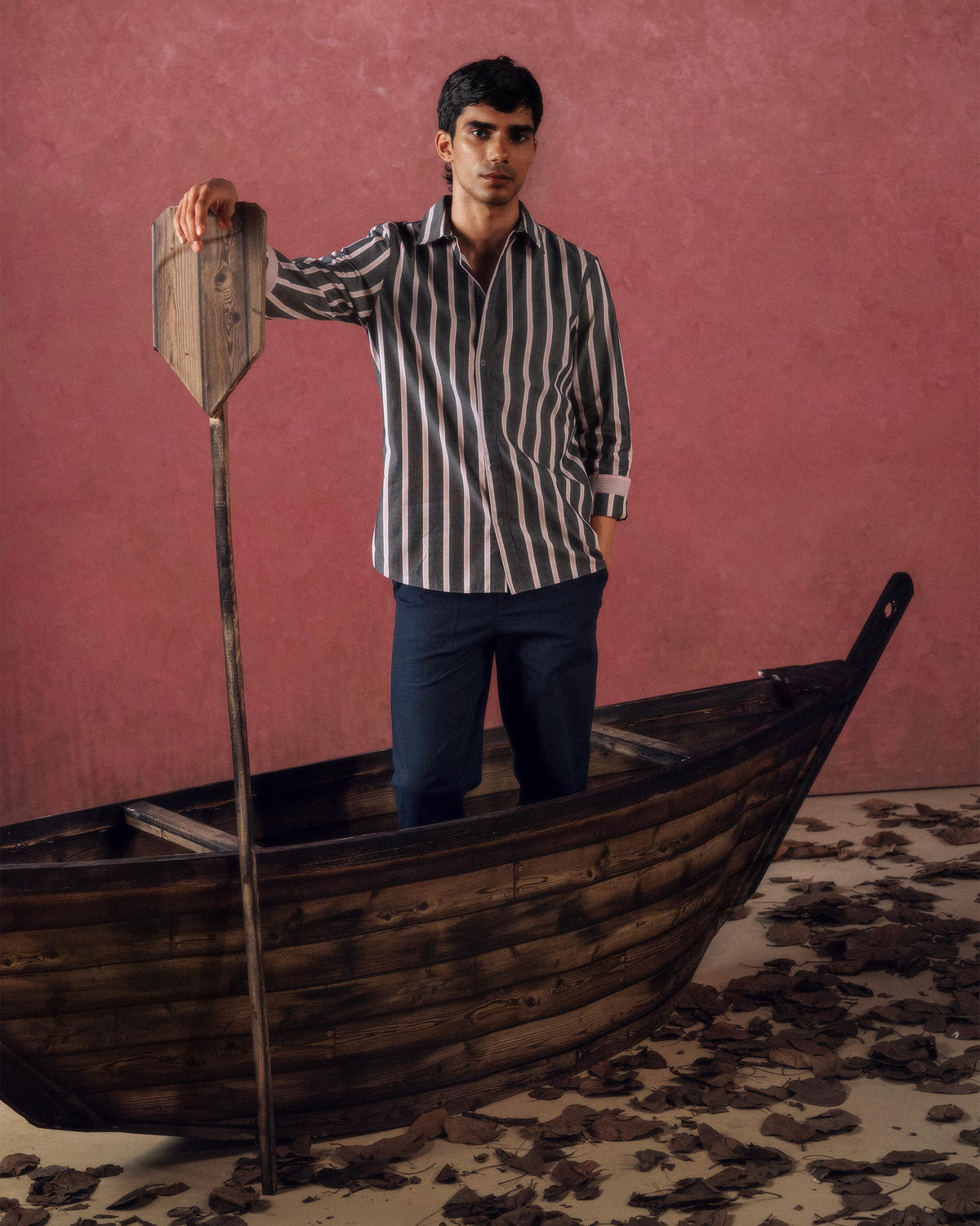 Person wearing a charcoal and pink striped Classic shirt with rolled sleeves.
