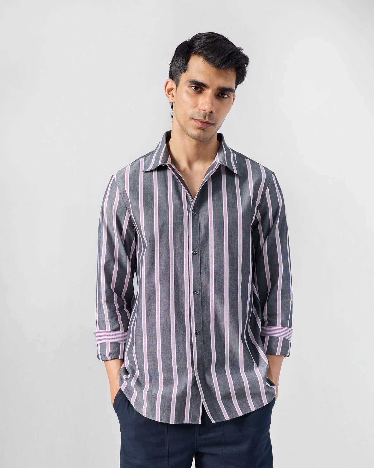 Person wearing a charcoal and pink striped Classic shirt with rolled sleeves.