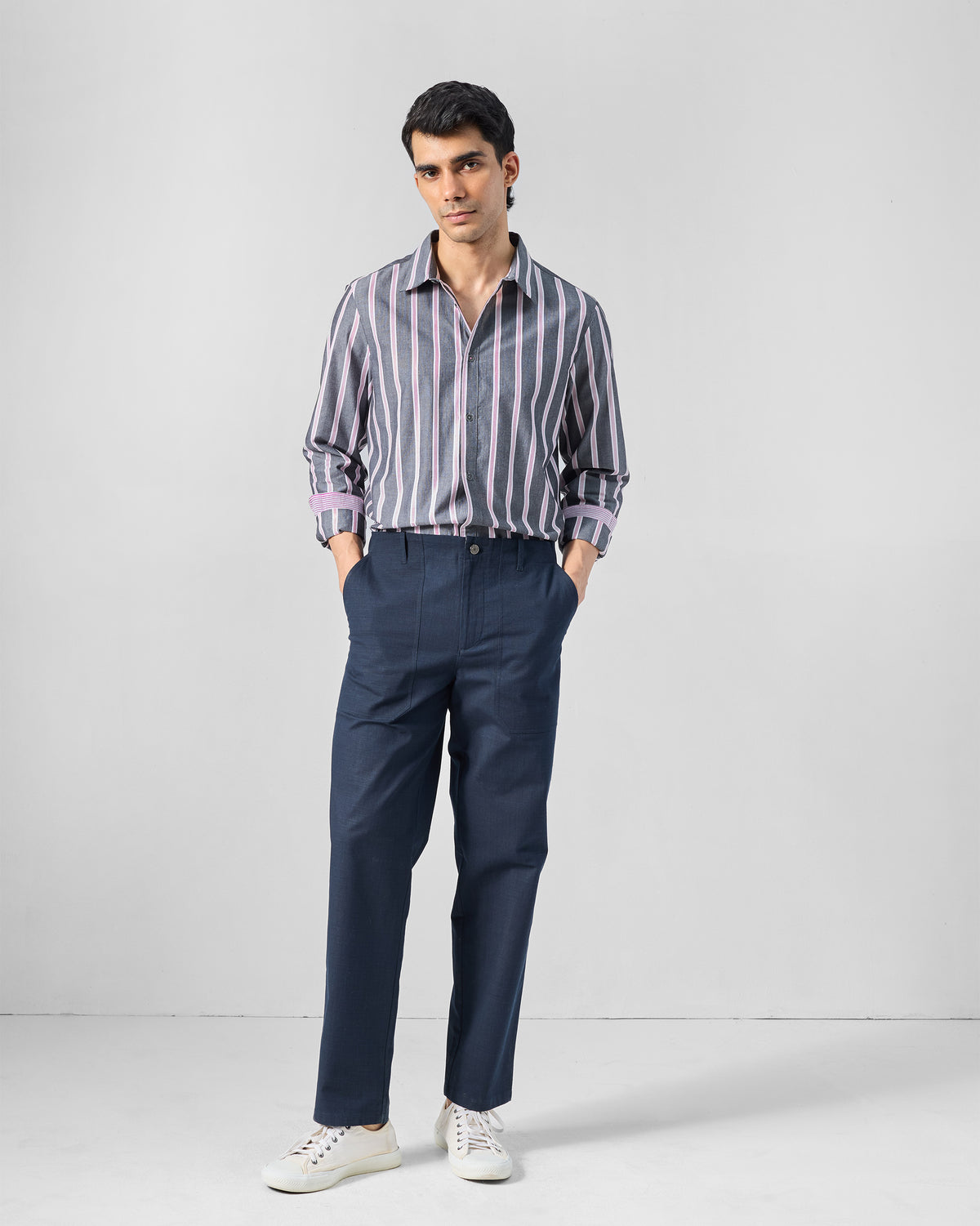 Person wearing a tucked charcoal and pink striped Classic shirt.