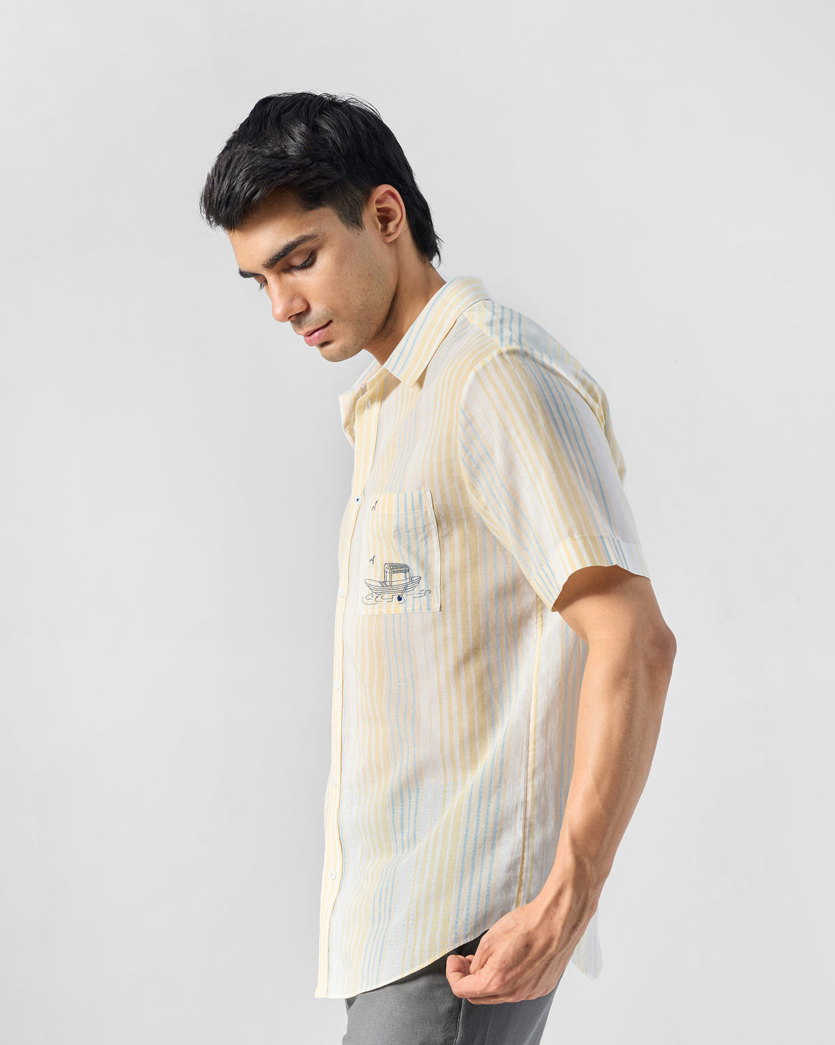 Side view of a yellow and blue striped Flow Half Sleeve Shirt with boat embroidery.