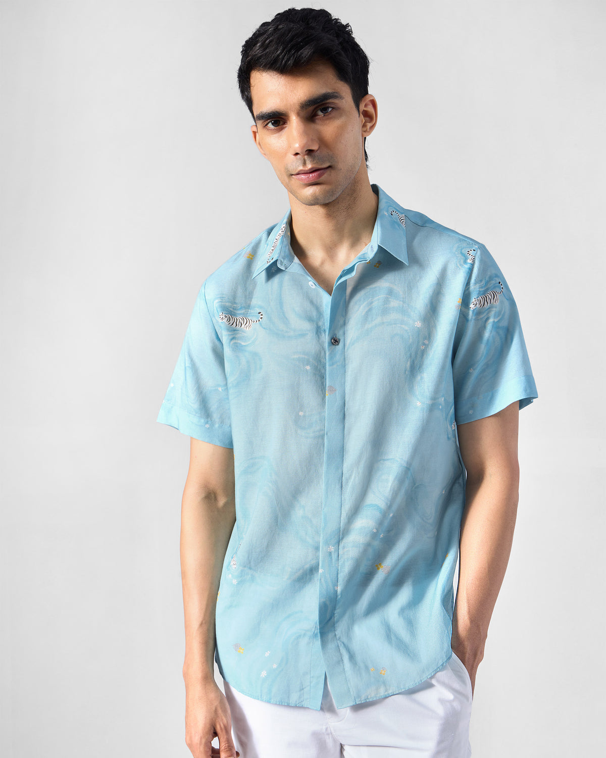 Light blue printed Riverine shirt showing white tiger embroidery on the chest.