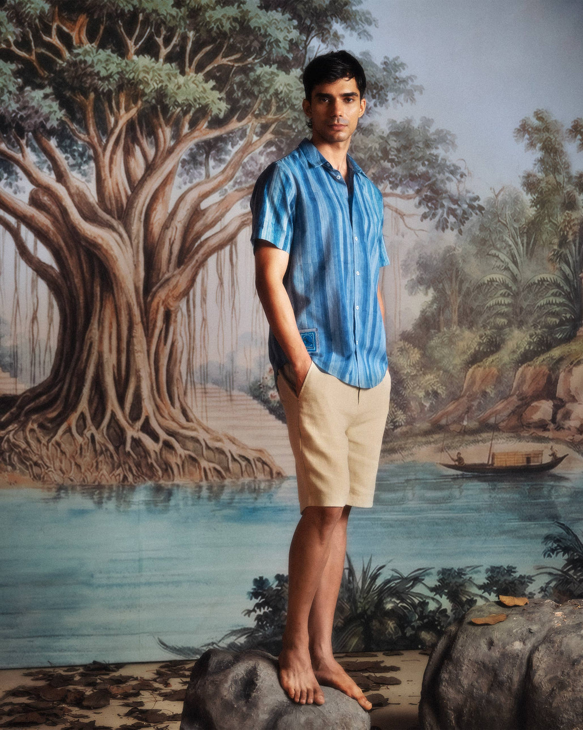 Person wearing a blue Ganga shirt with tonal stripes.