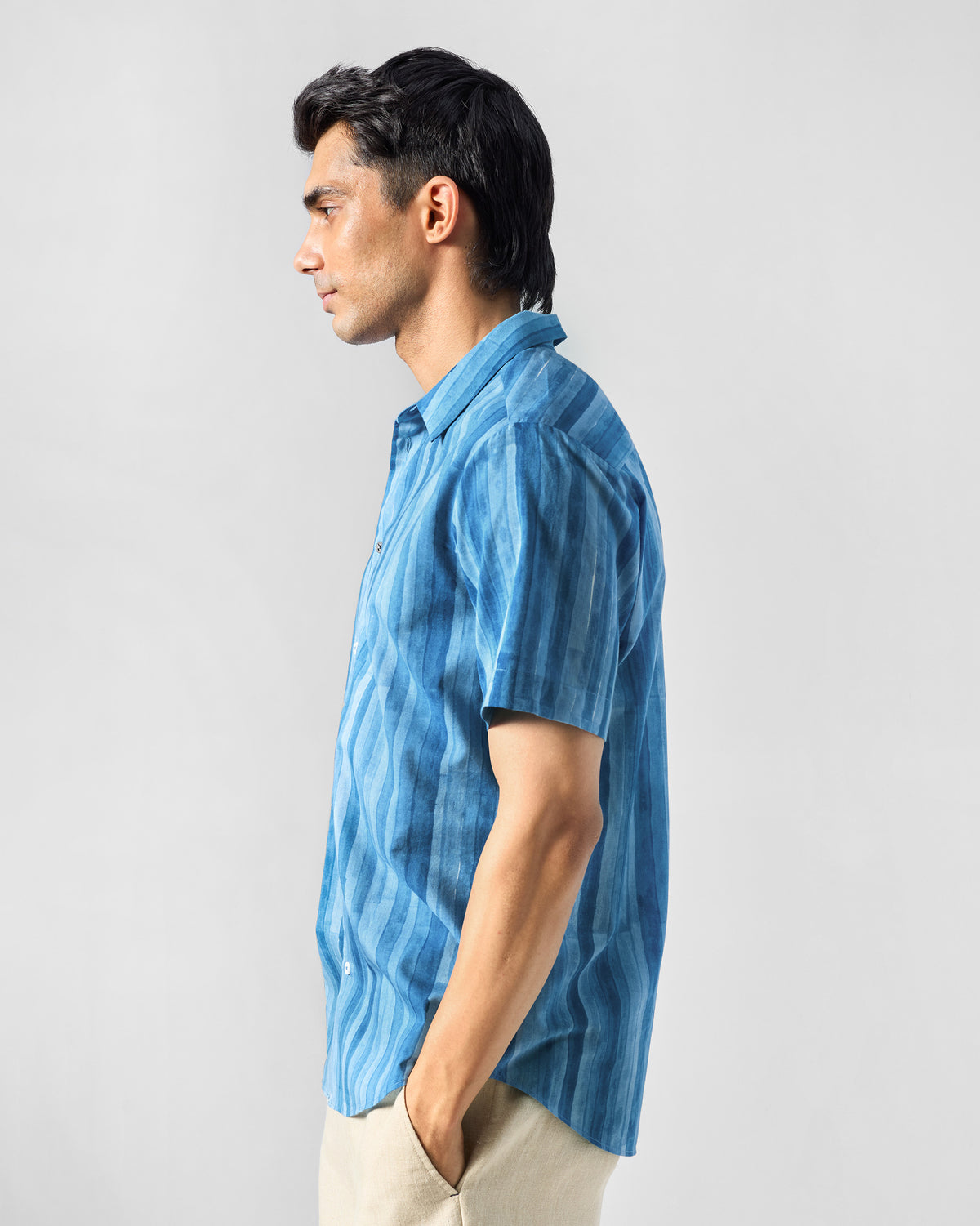 Side view of a blue Ganga shirt with tonal stripes.