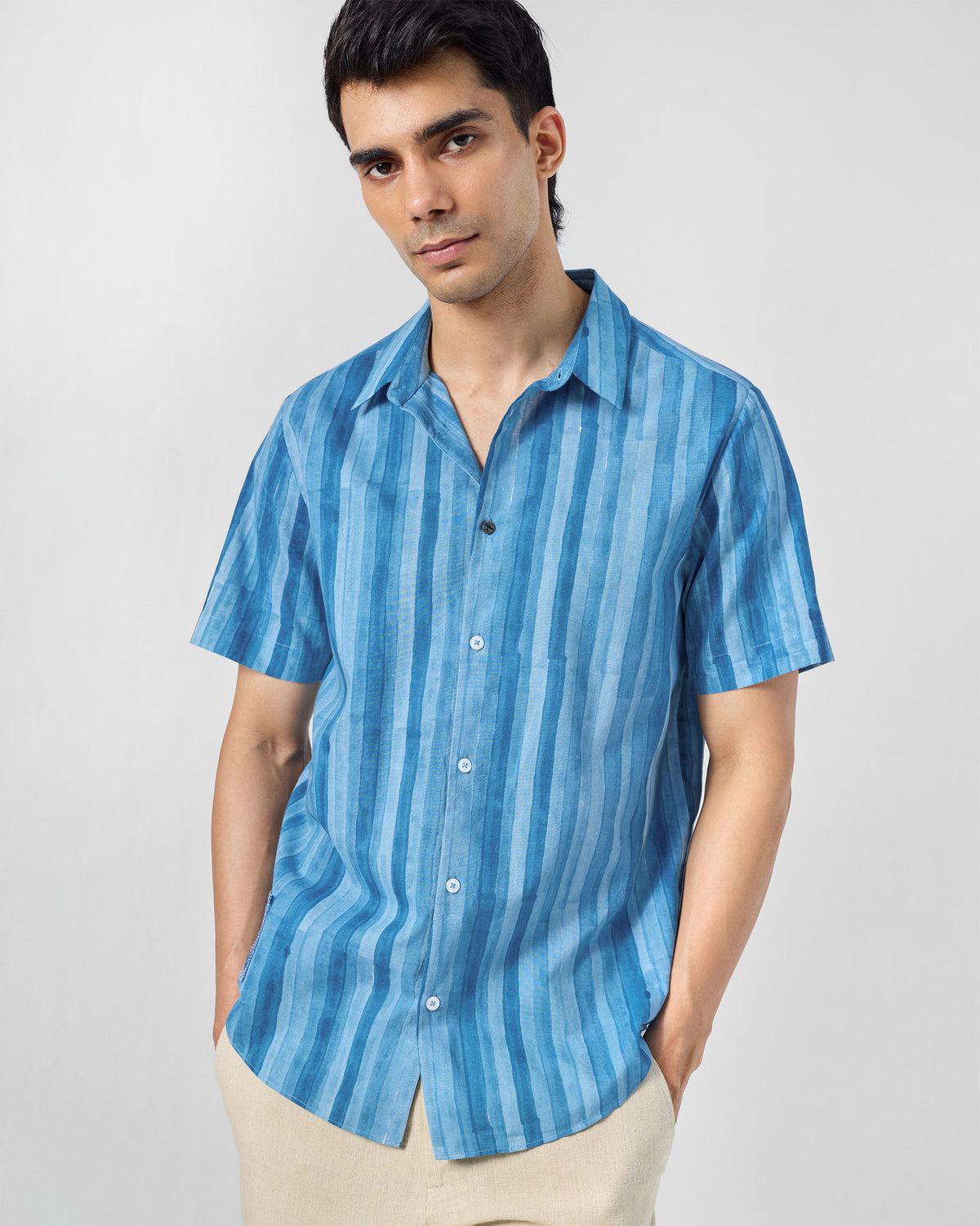 Person wearing a blue Ganga shirt with tonal stripes.