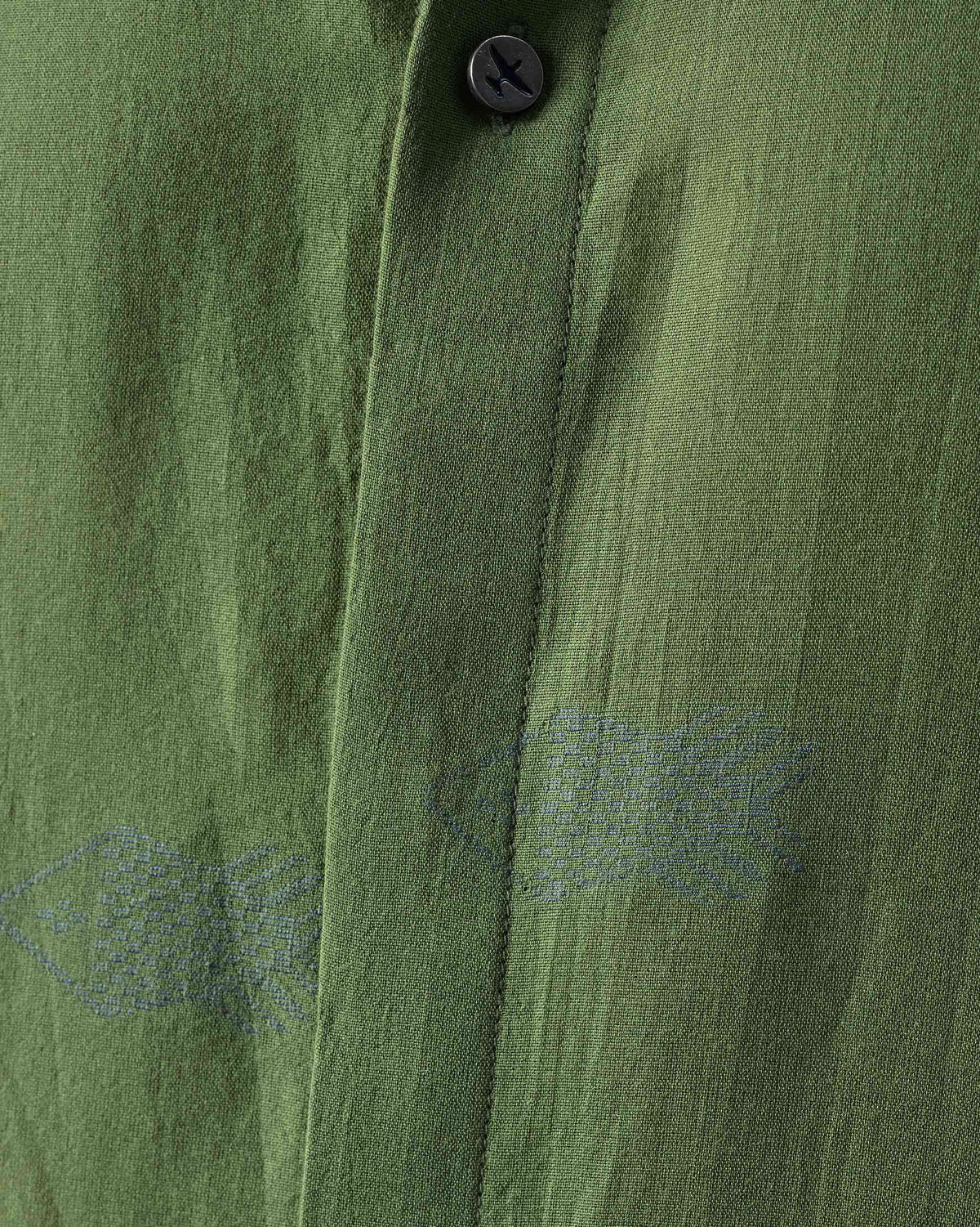 Close-up of a green Riverine shirt placket with tonal fish embroidery.