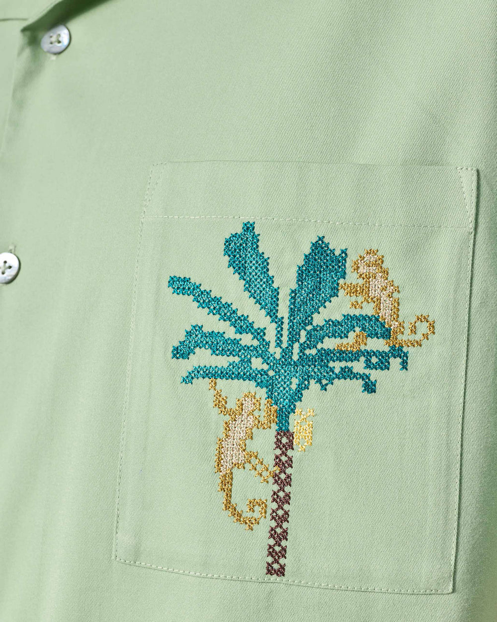 Close-up of Jaisal Shirt pocket with palm tree and monkey embroidery.