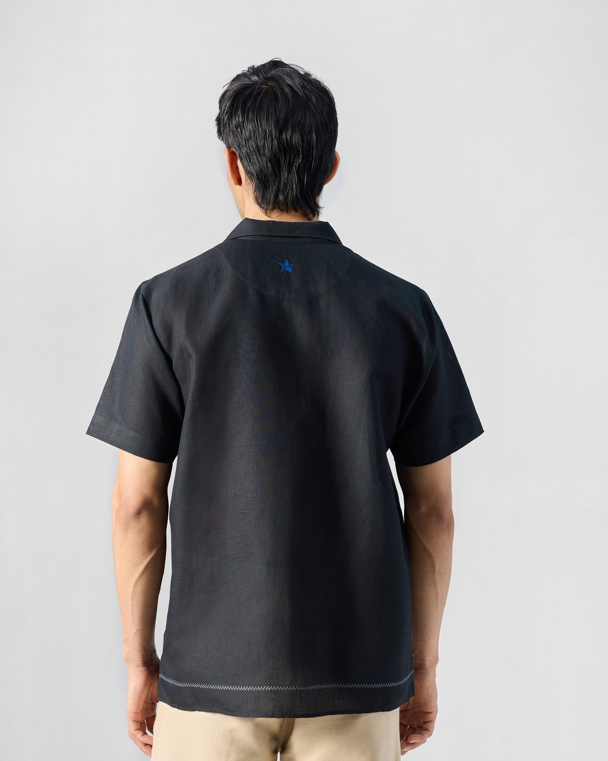 Back of a black Delta shirt with a blue star on the yoke.