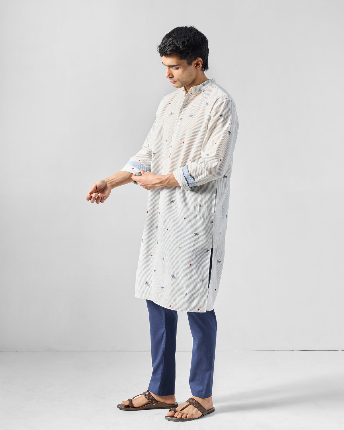 Person wearing a charcoal and white Bageecha kurta with animal embroidery.