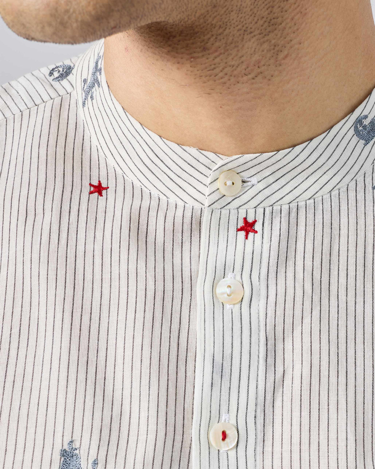 Close-up of a charcoal and white Bageecha kurta with red star embroidery.