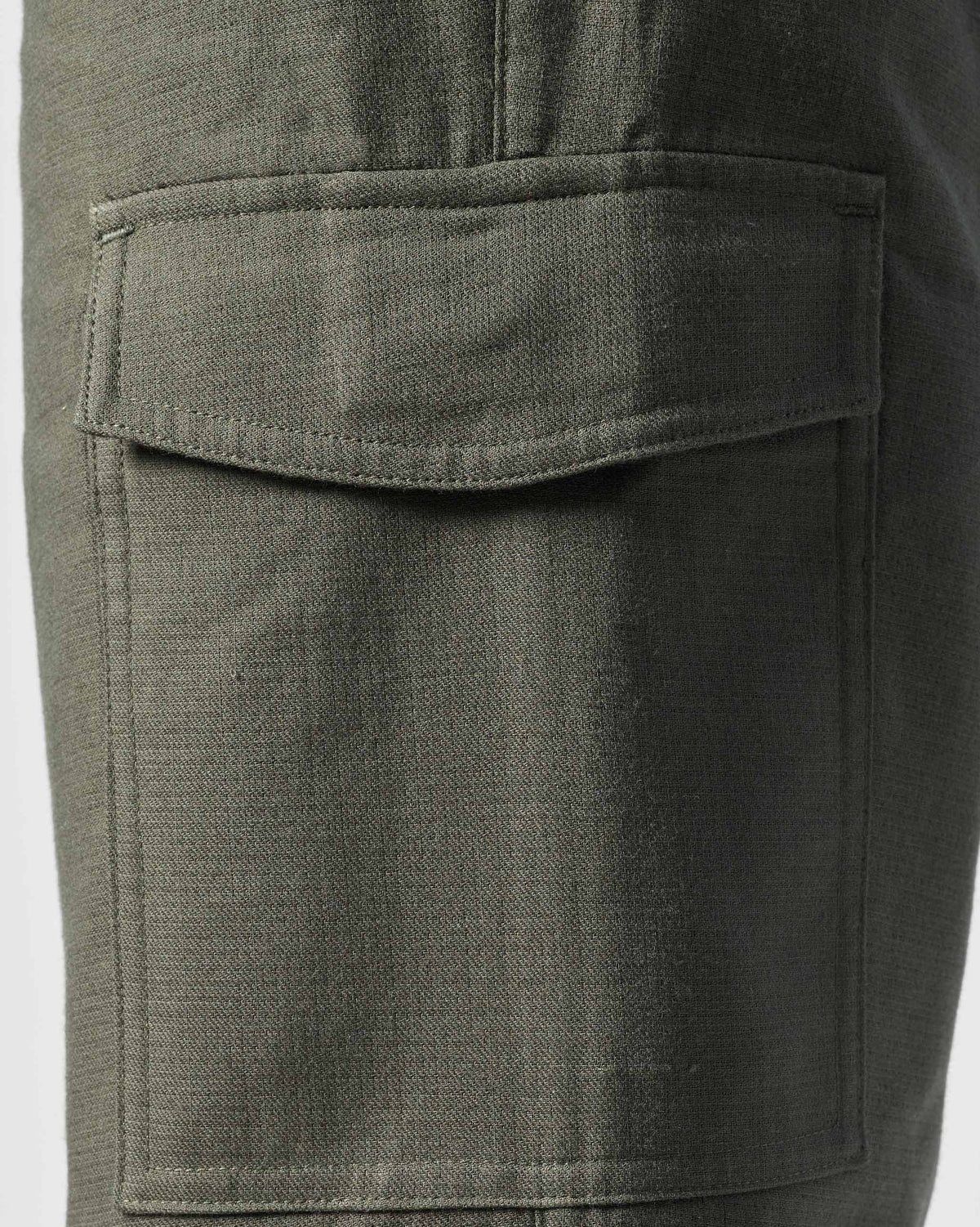 Close-up of an olive Riverbank pants cargo pocket with a flap.