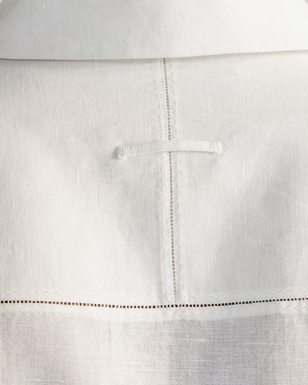 Close-up of hemstitch seams and a locker loop on a white Egret shirt.