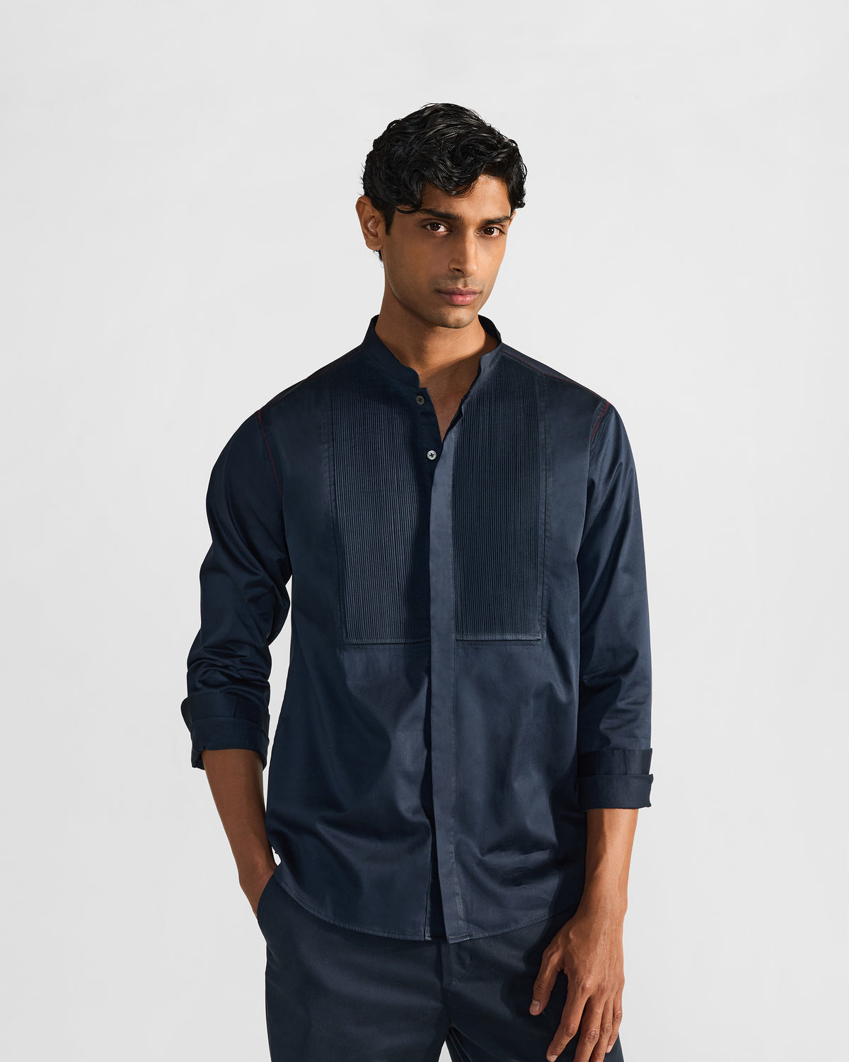 Person wearing a navy Nightjar shirt with a pleated bib panel.