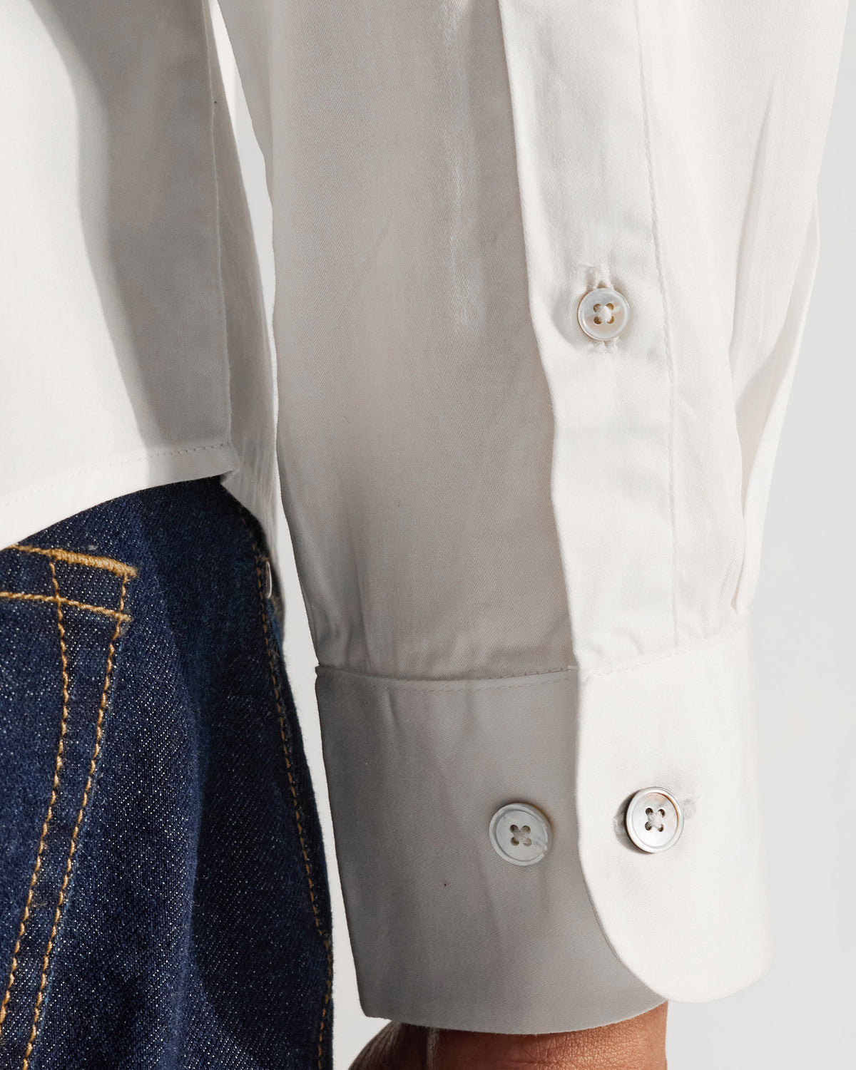 Close-up of a white Badger shirt cuff with pearl buttons.