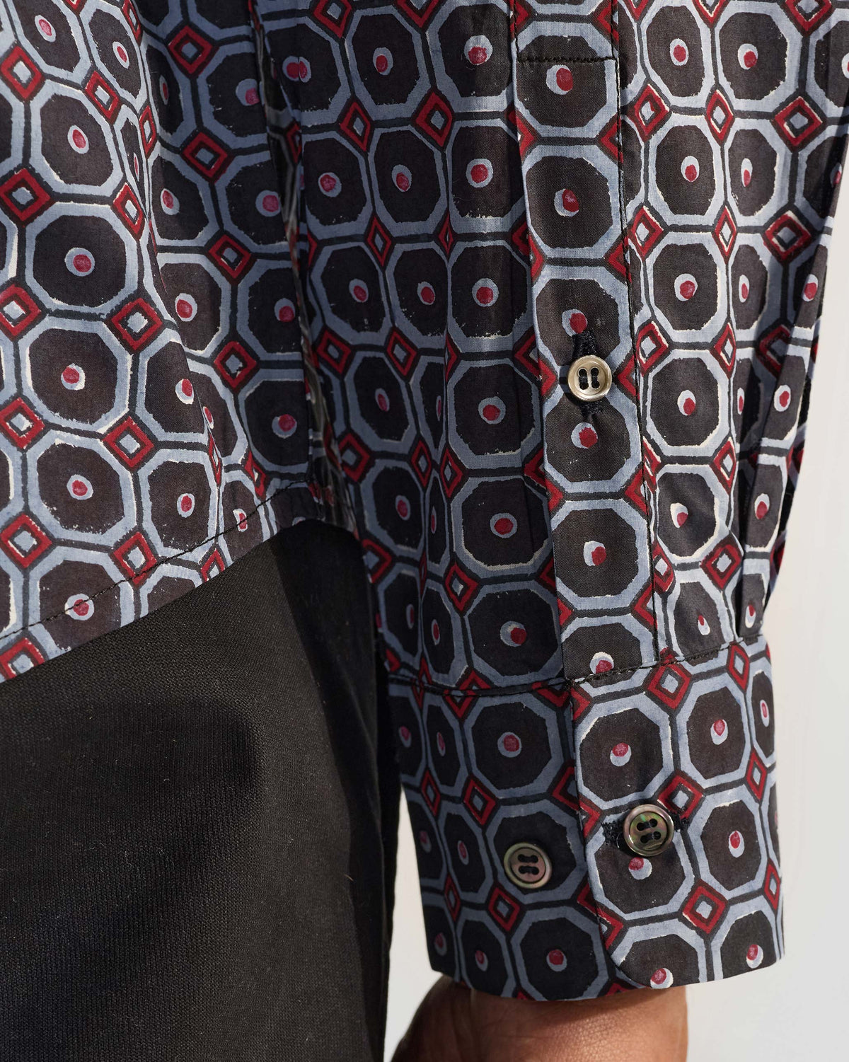 Close-up of Wood Pigeon Shirt cuff with geometric print and dark buttons.