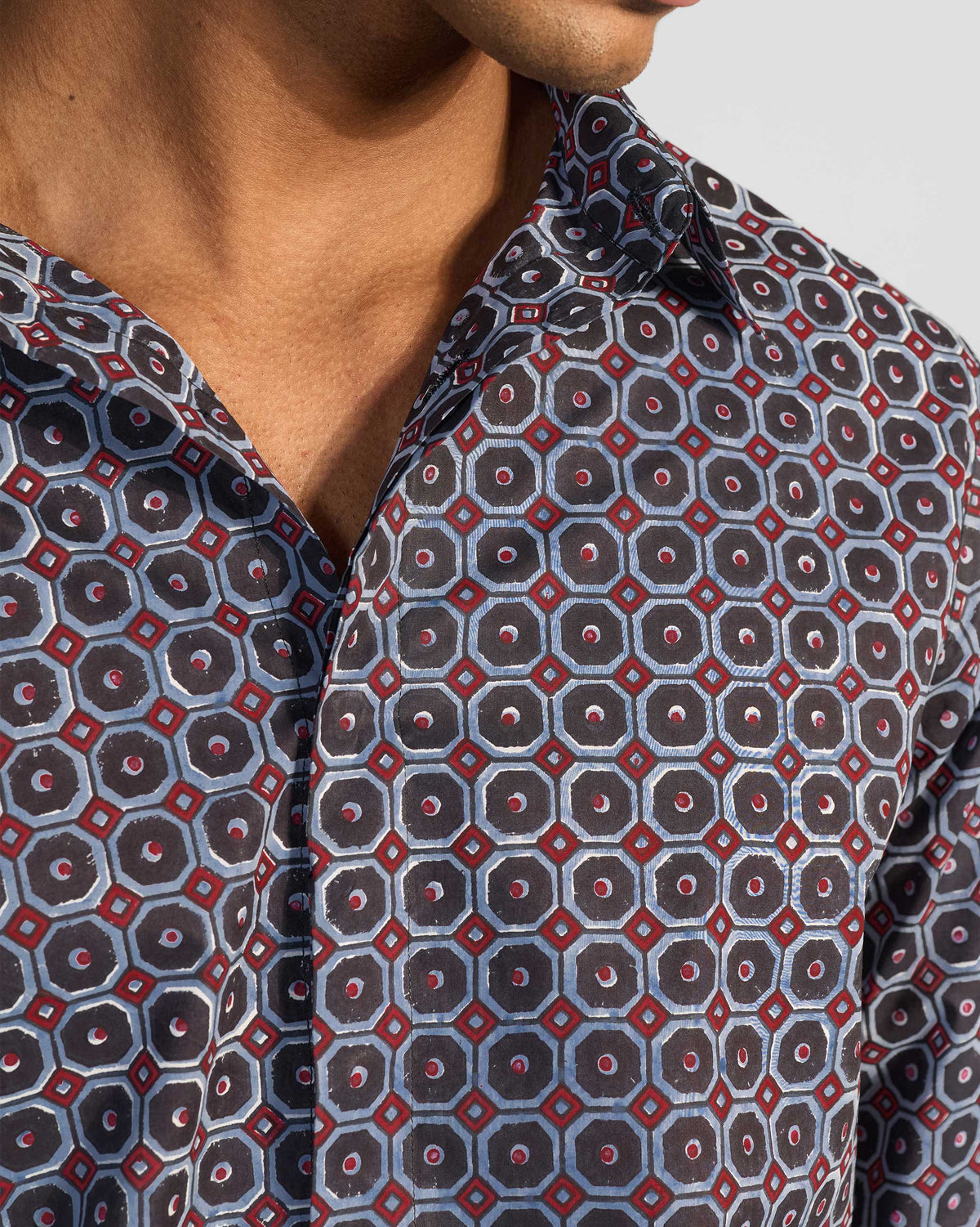 Close-up of Wood Pigeon Shirt collar with geometric print and red accents.