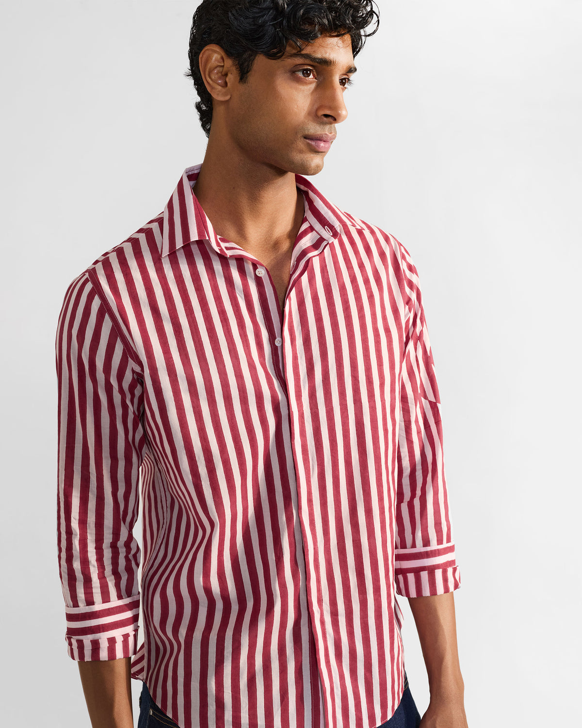 Person wearing a red and white striped Civet shirt with rolled cuffs.