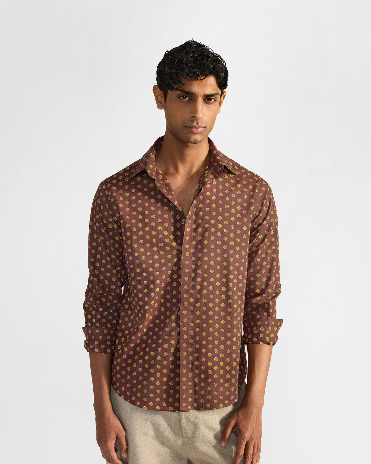 Person wearing a brown Pipit Shirt with an all-over lime circular print.