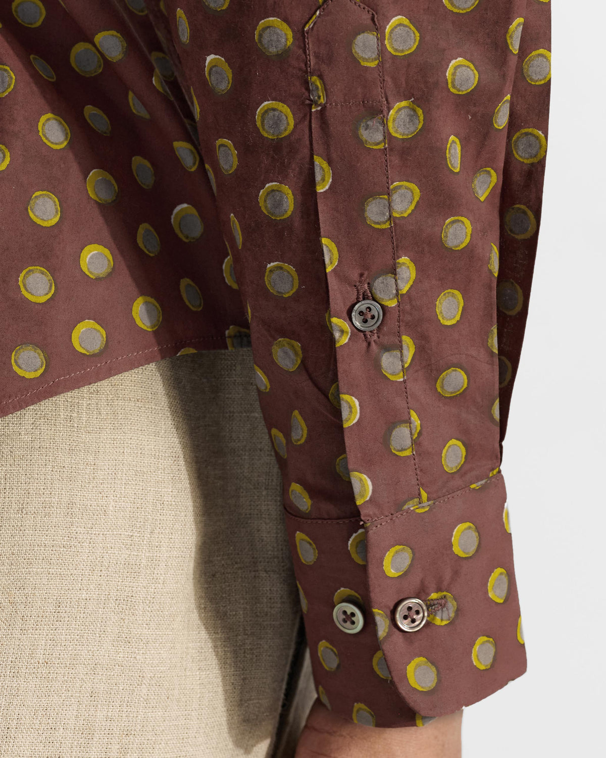 Close-up of a brown Pipit Shirt cuff showing the circular block print.