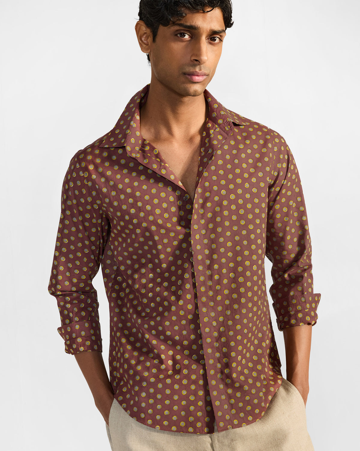 Person wearing a brown Pipit Shirt with rolled sleeves and a circular print.