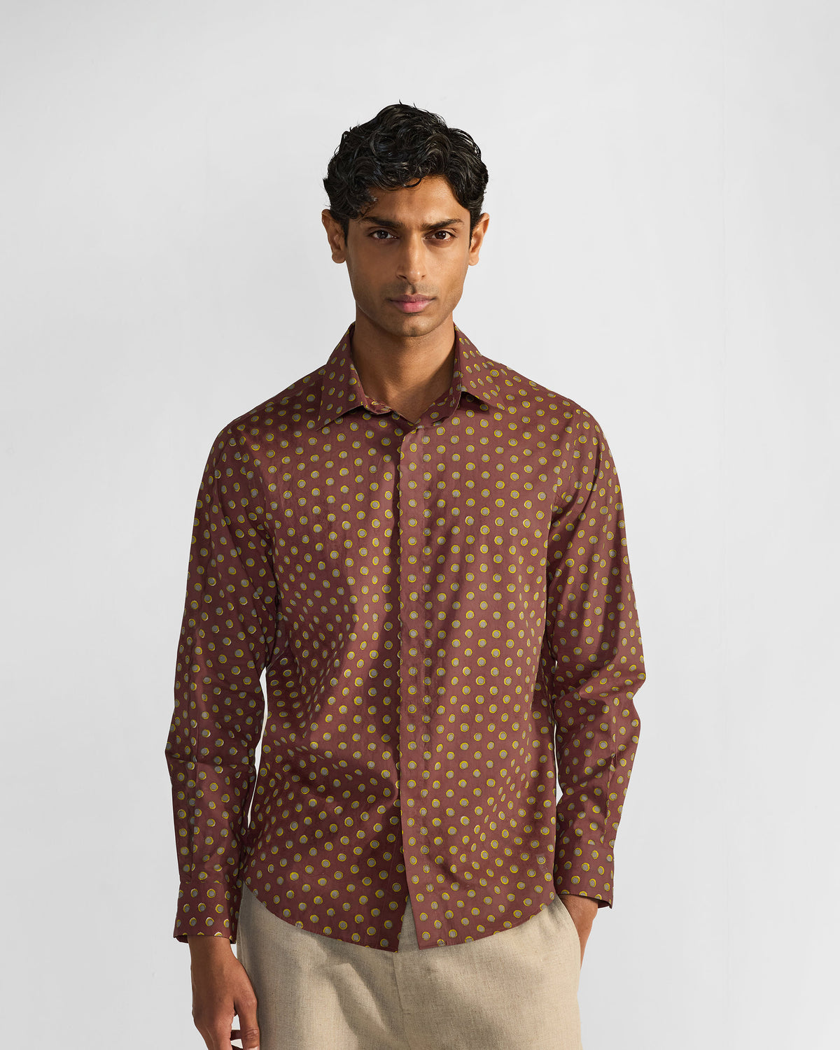 Person wearing a brown Pipit Shirt covered in a lime circular print.
